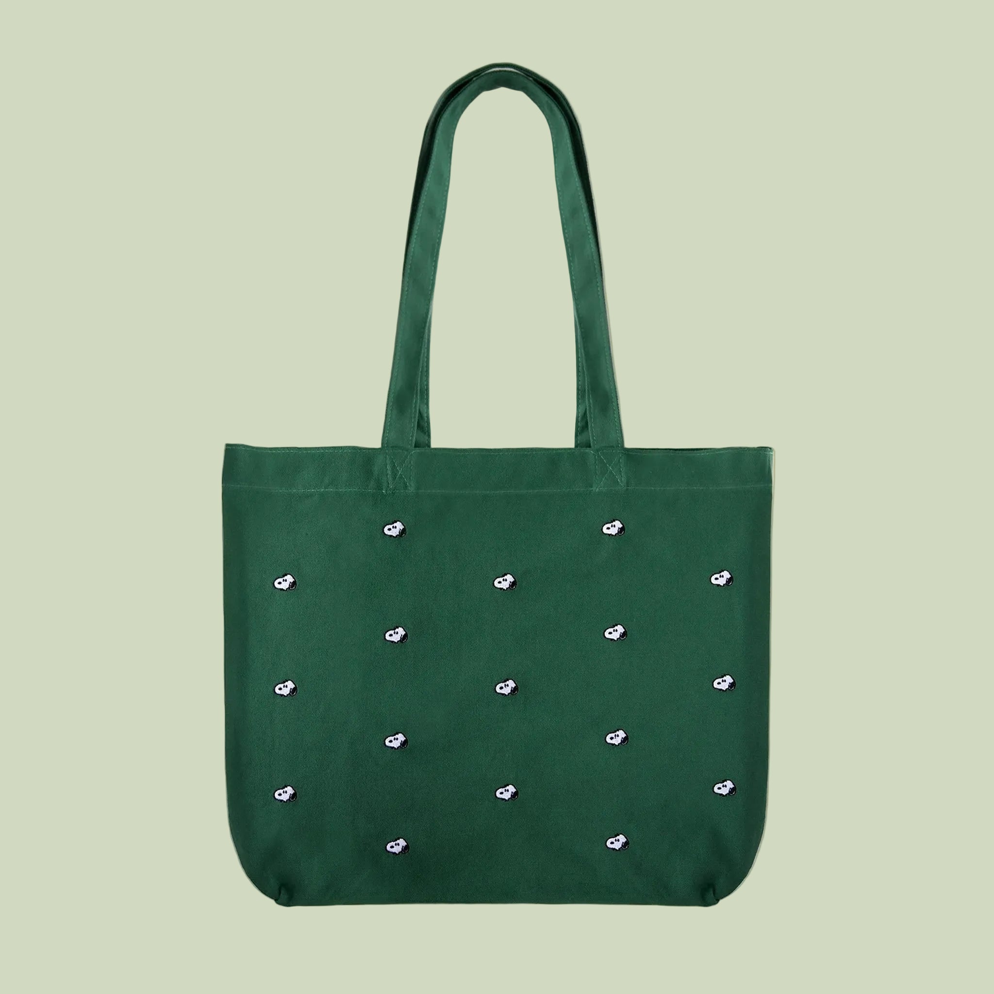 Green tote bag with decorative Snoopy elements on a white background