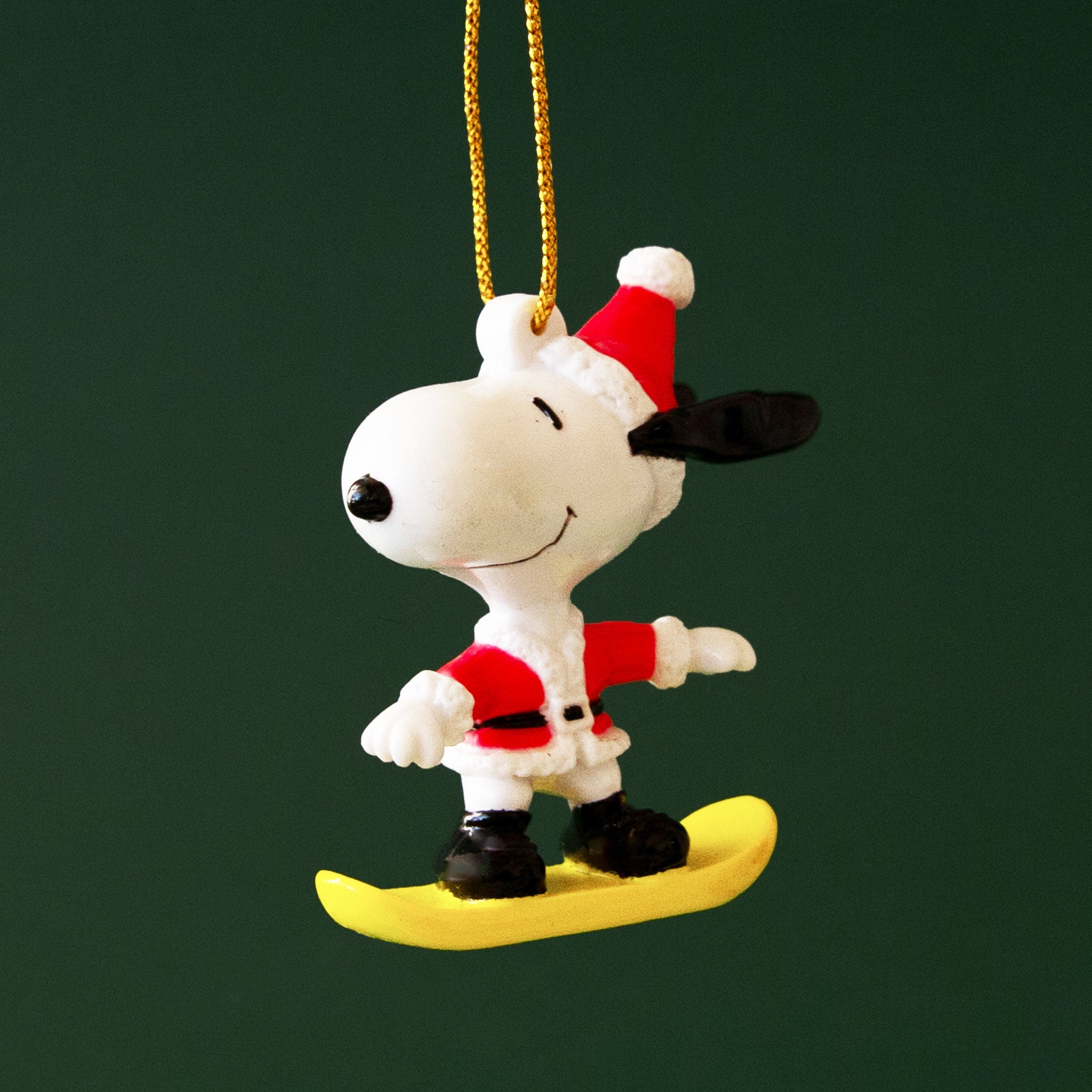 A snoopy ornament on a snowboard. 