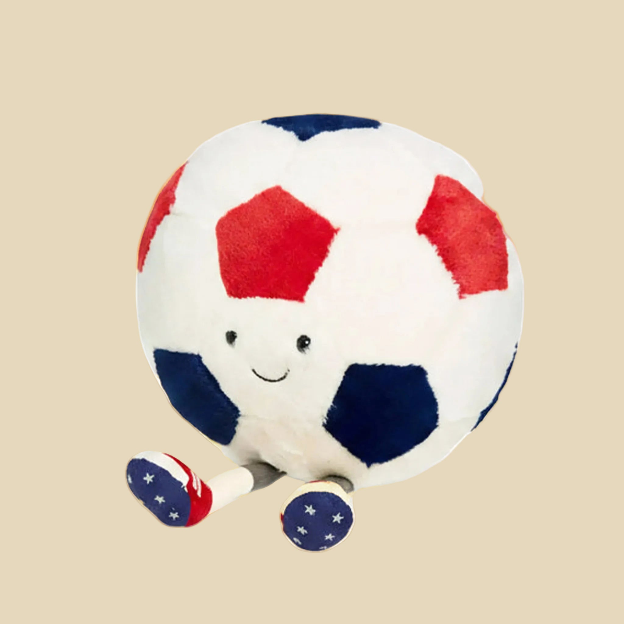 Plush soccer ball toy with a smiling face on a gray background