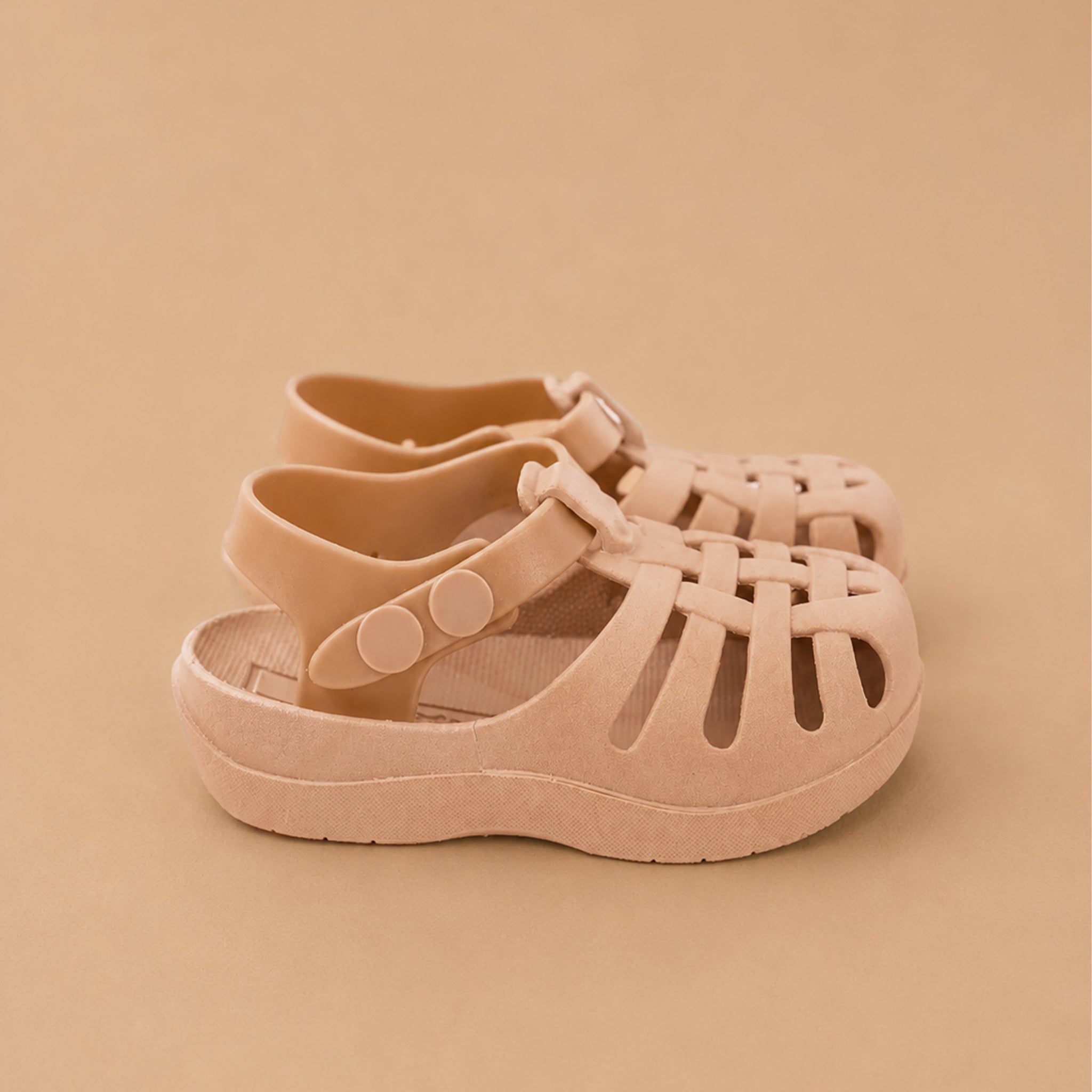 Pair of beige/soft blush sandals on a beige background