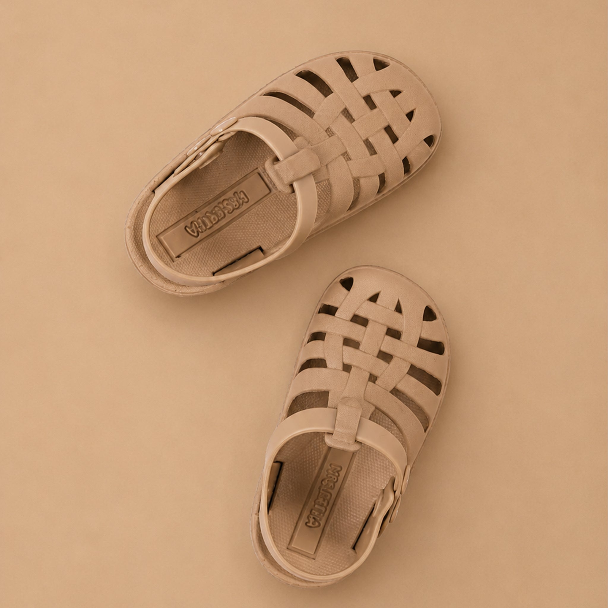 Pair of beige sandals on a beige background