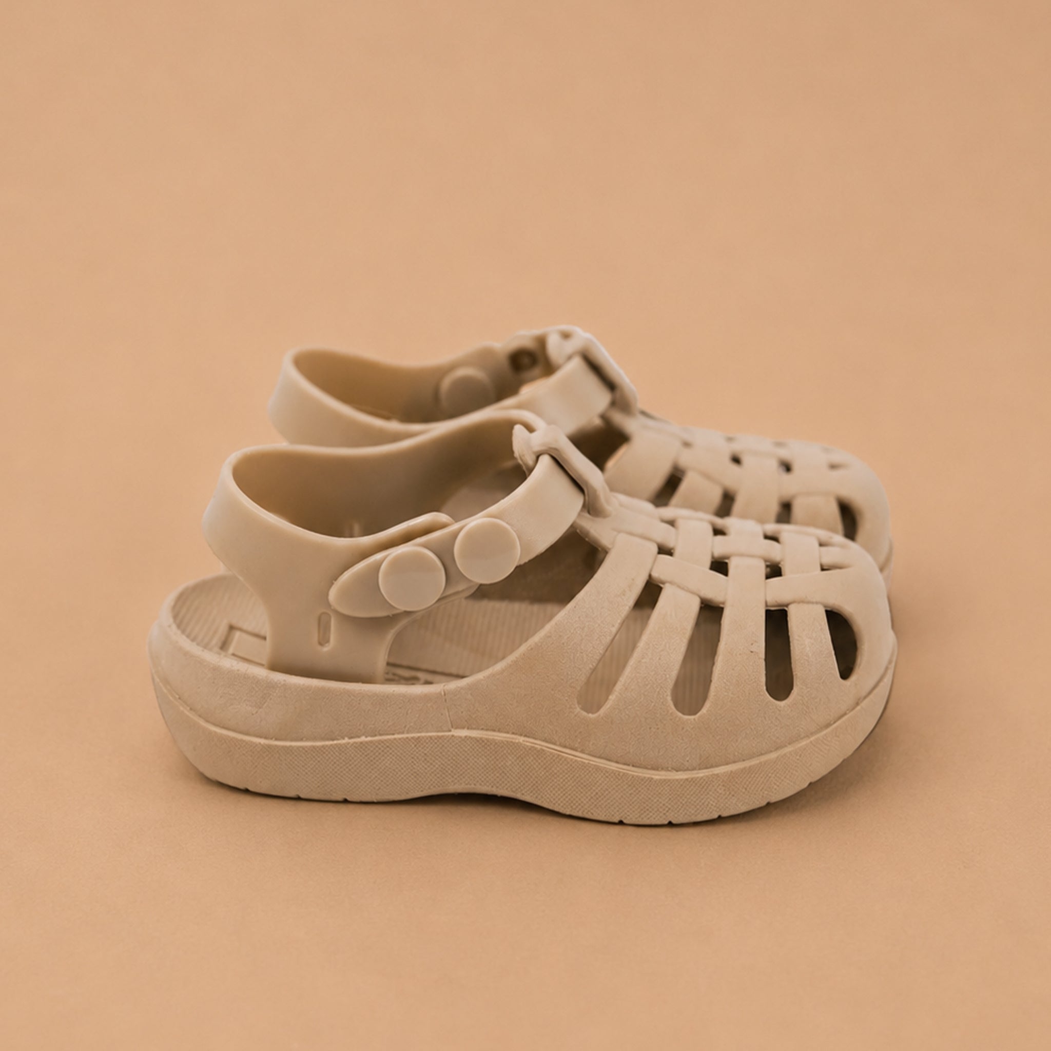 Pair of beige sandals on a beige background
