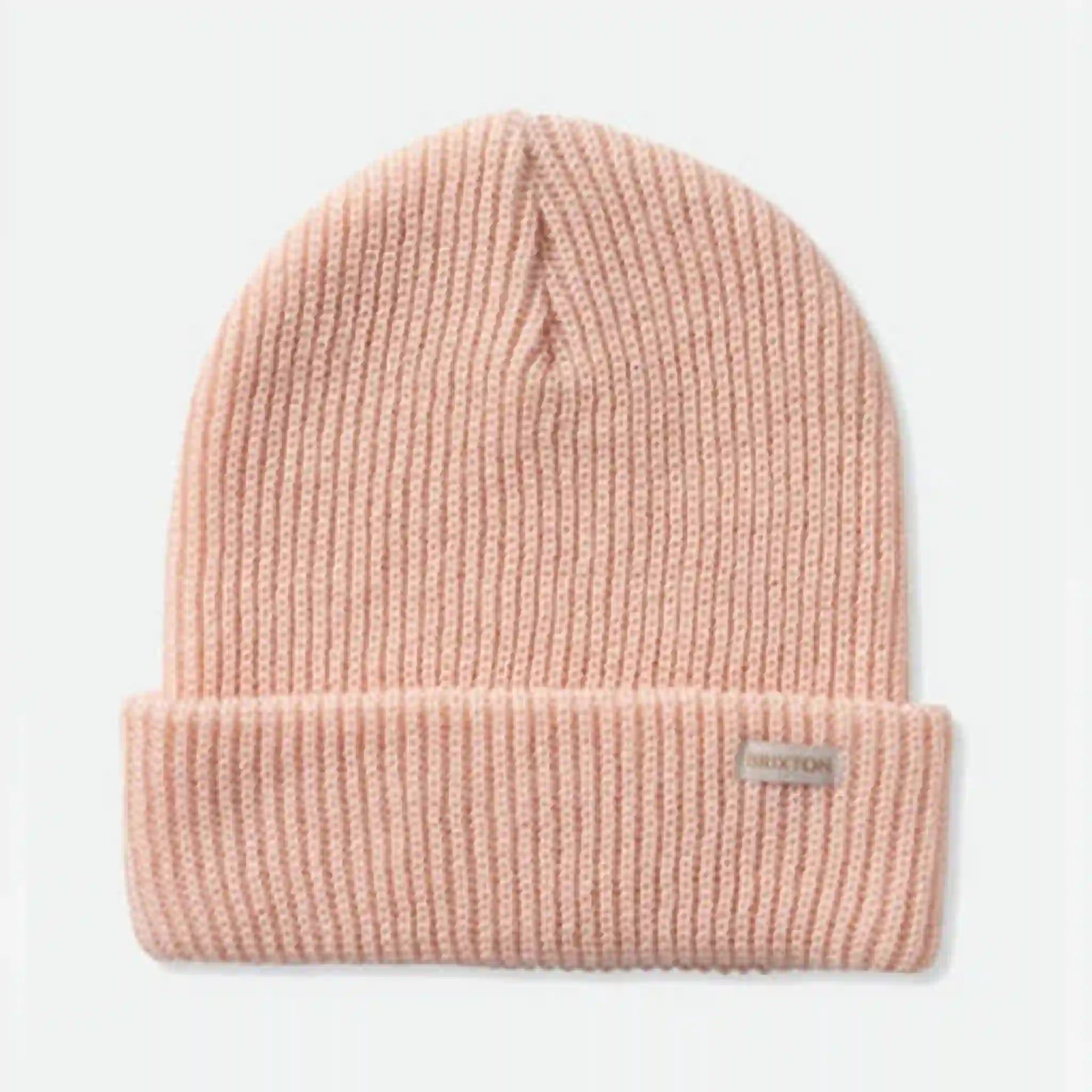 On a white background is a light pink knit beanie with a small Brixton logo tag on the bottom right. 