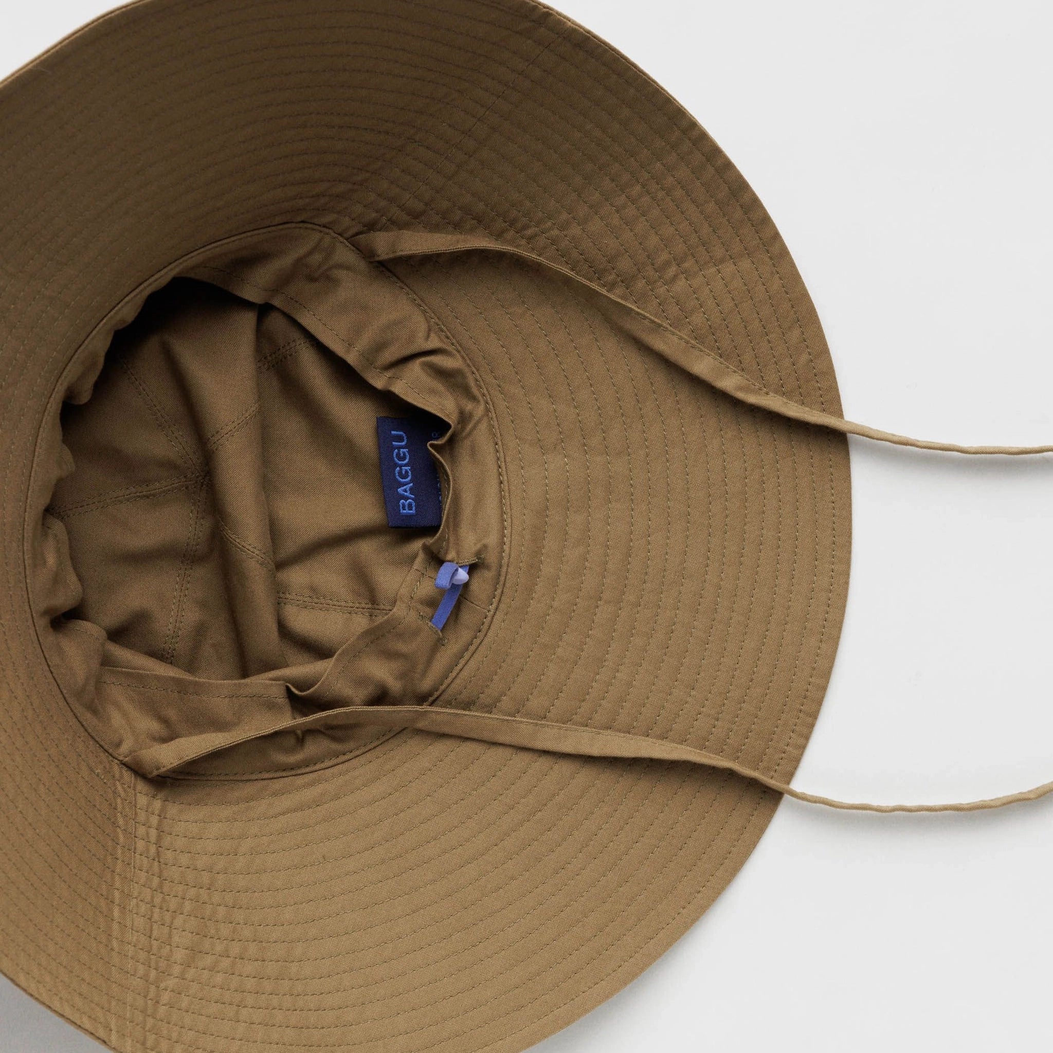 On a white background is a flexible sun hat in a brown shad with a wide brim and two straps for securing around the neck.
