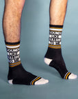 On a blue background is a model wearing a pair of black socks with yellow and white details along with text that reads, "Sounds Like Bullshit To Me".
