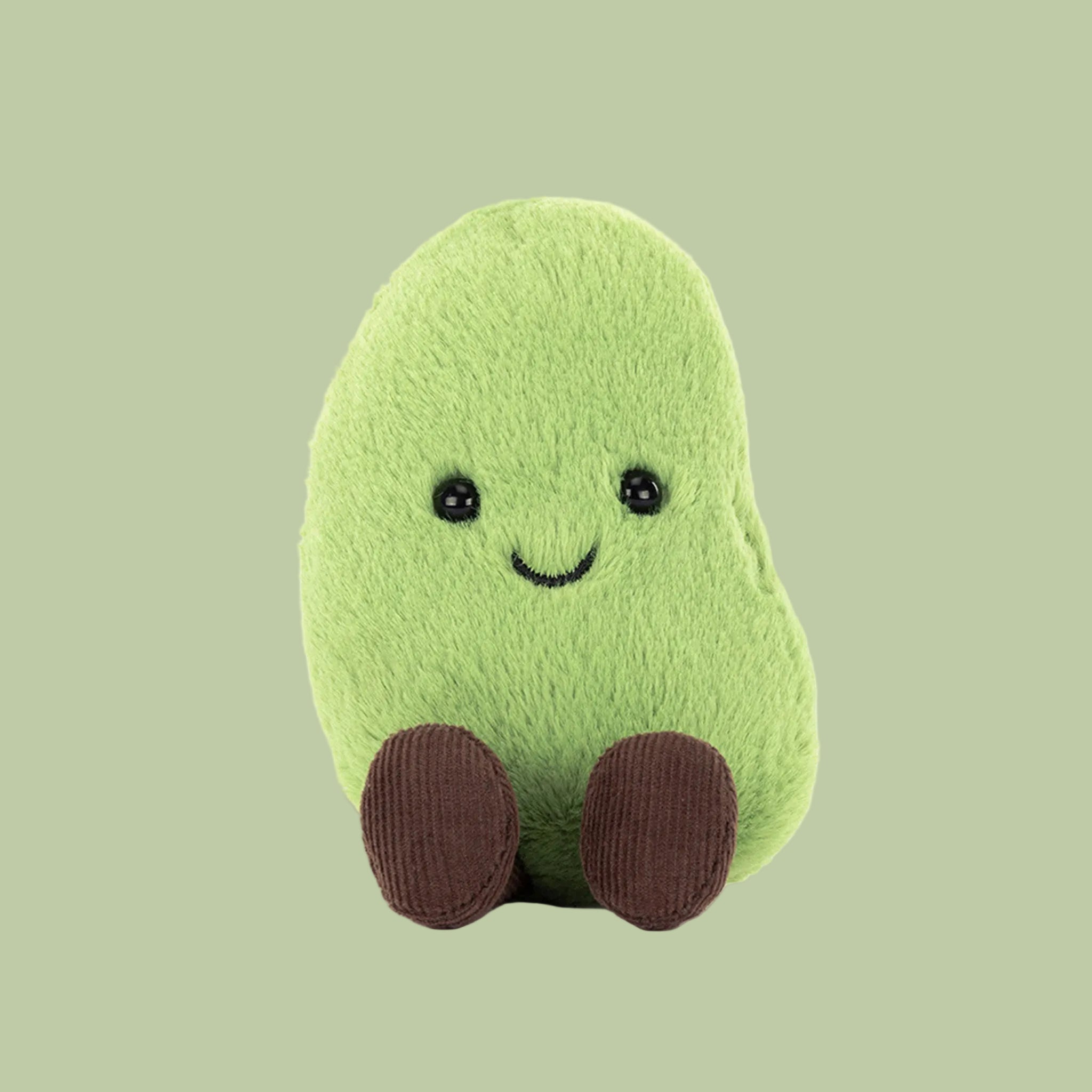 Green plush toy with a smiling face on a white background