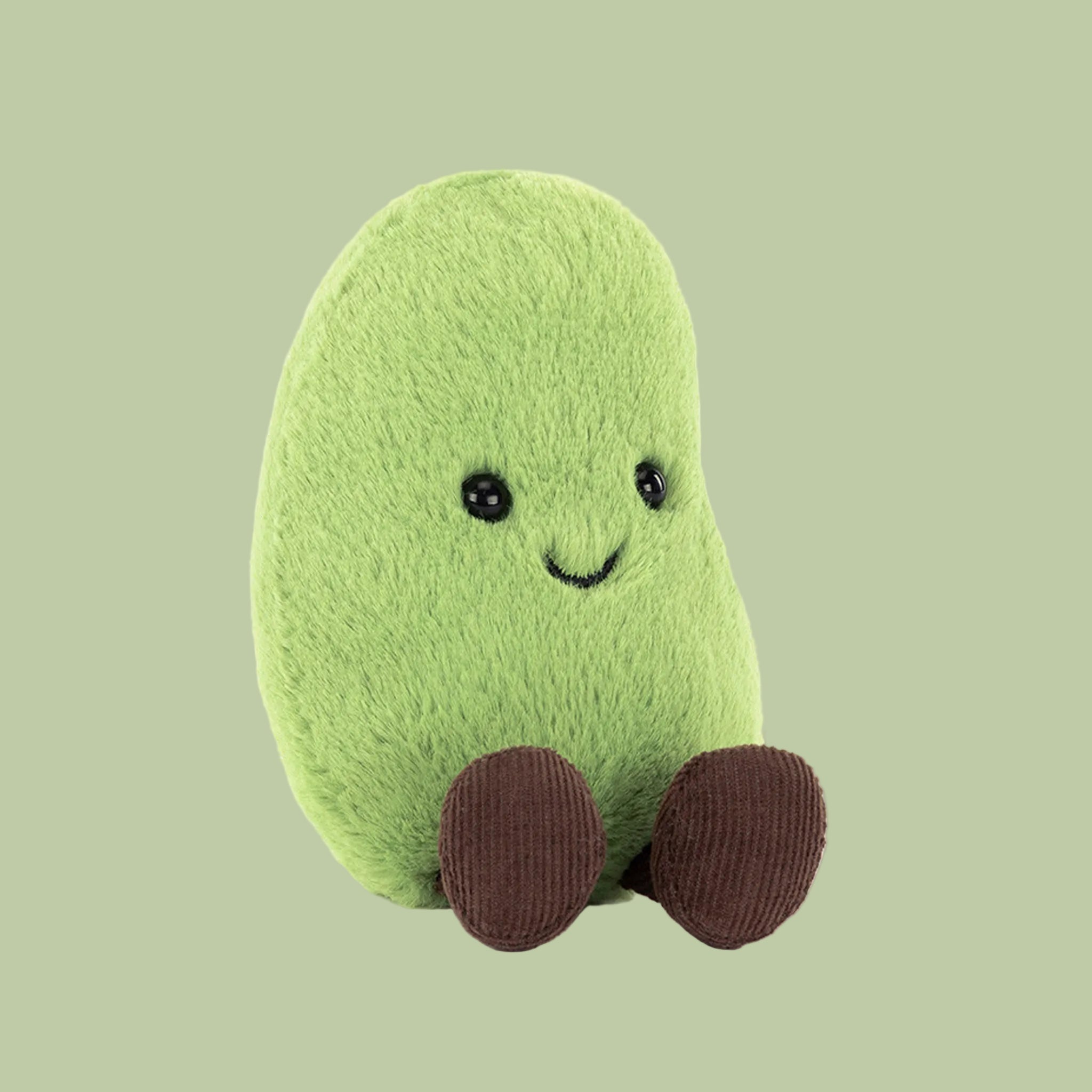 Green plush toy with a smiling face on a white background