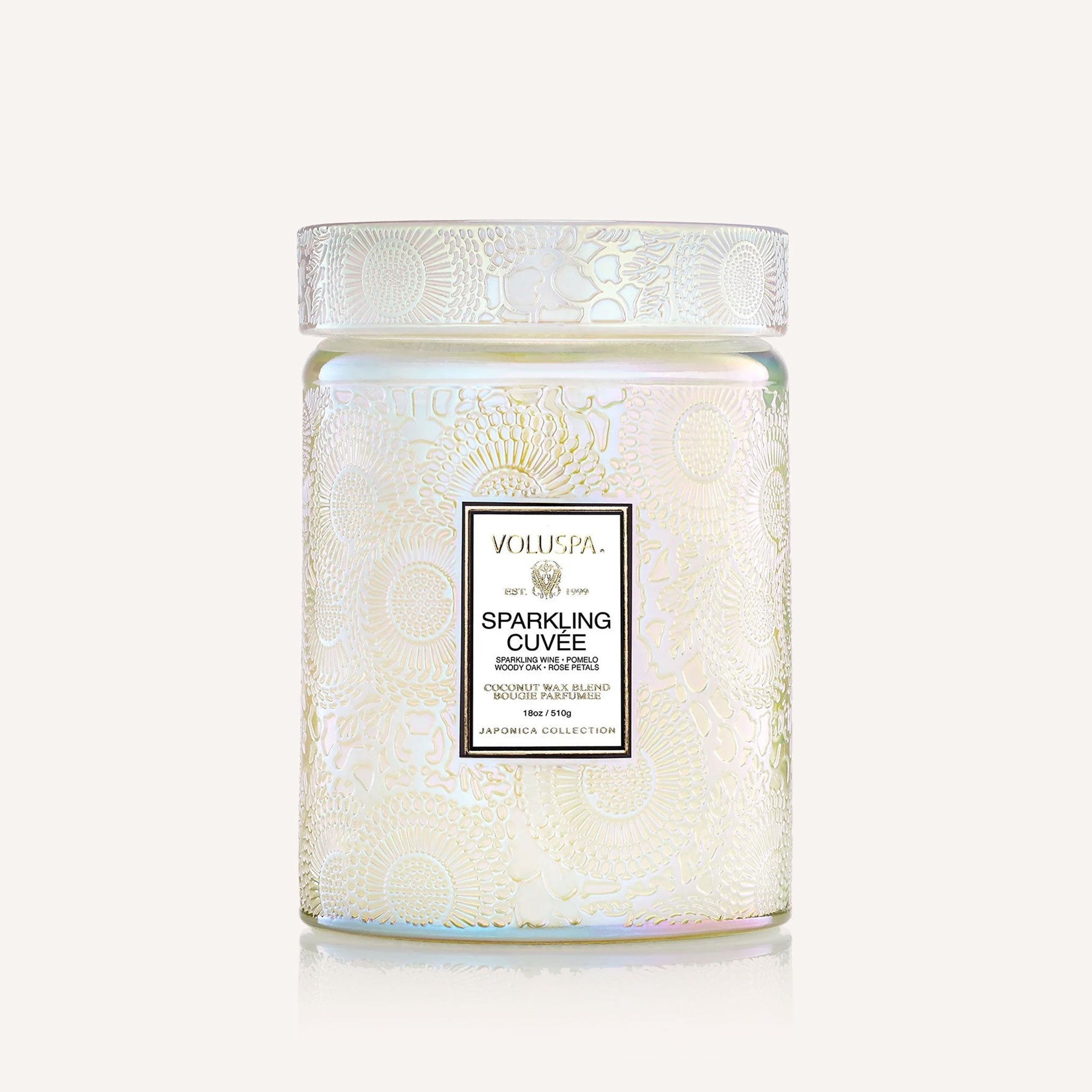 An irridescent embossed glass candle sits in the middle of the image.  The label on the glass candle reads, "Sparkling Cuvee"