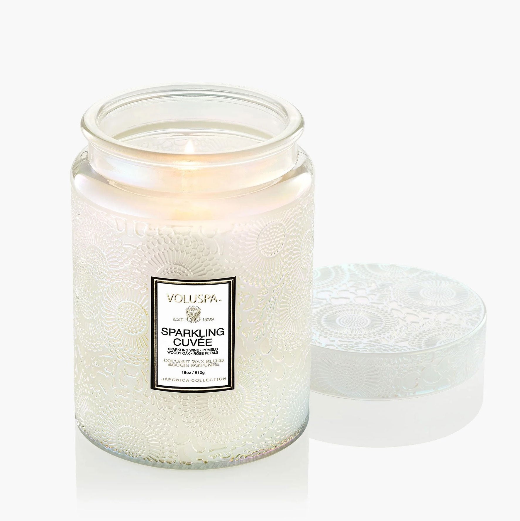 A white glass jar candle sits on a white background.  The candle label reads, " Sparkling Cuvee"