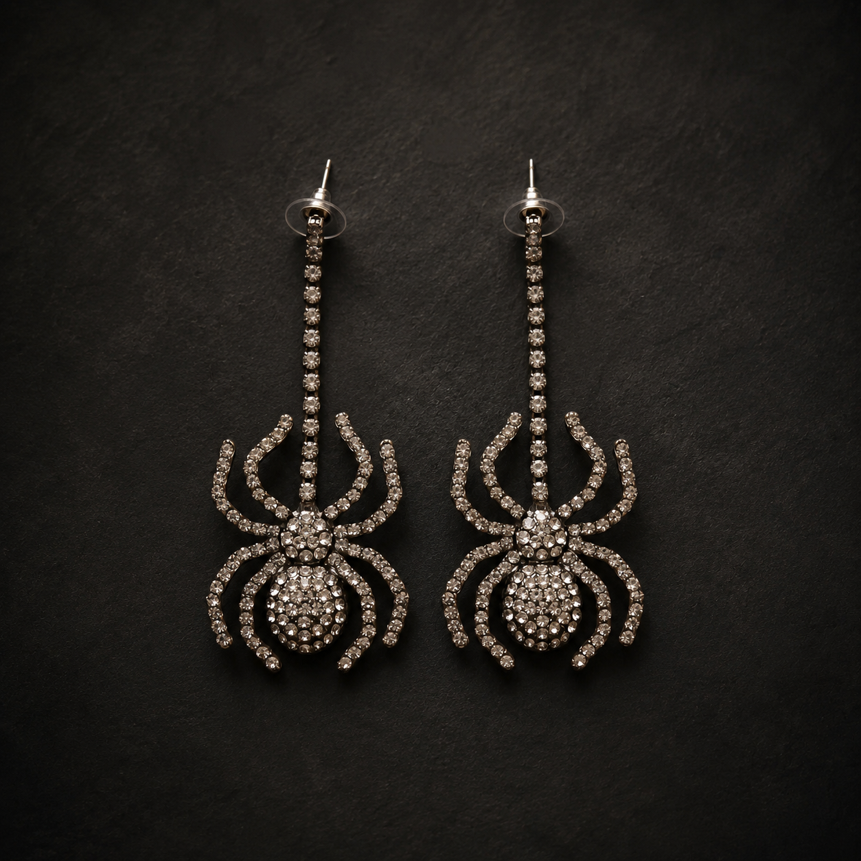spider earrings with gemstones on a black background.