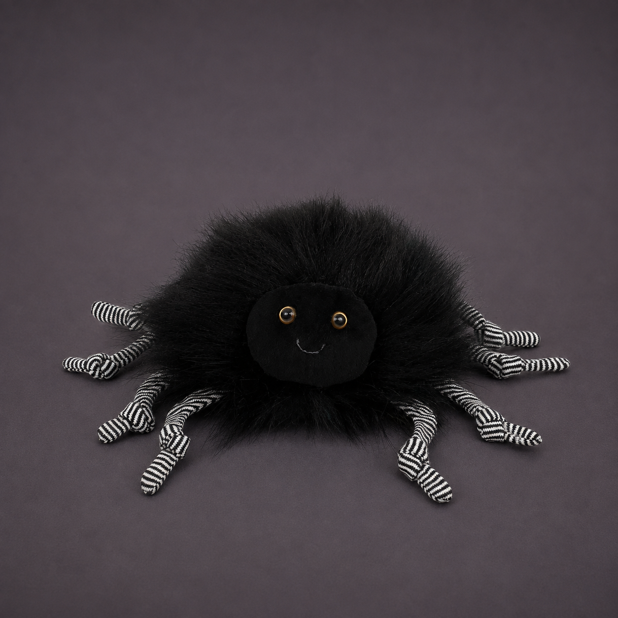 A fuzzy black spider stuffed toy. 