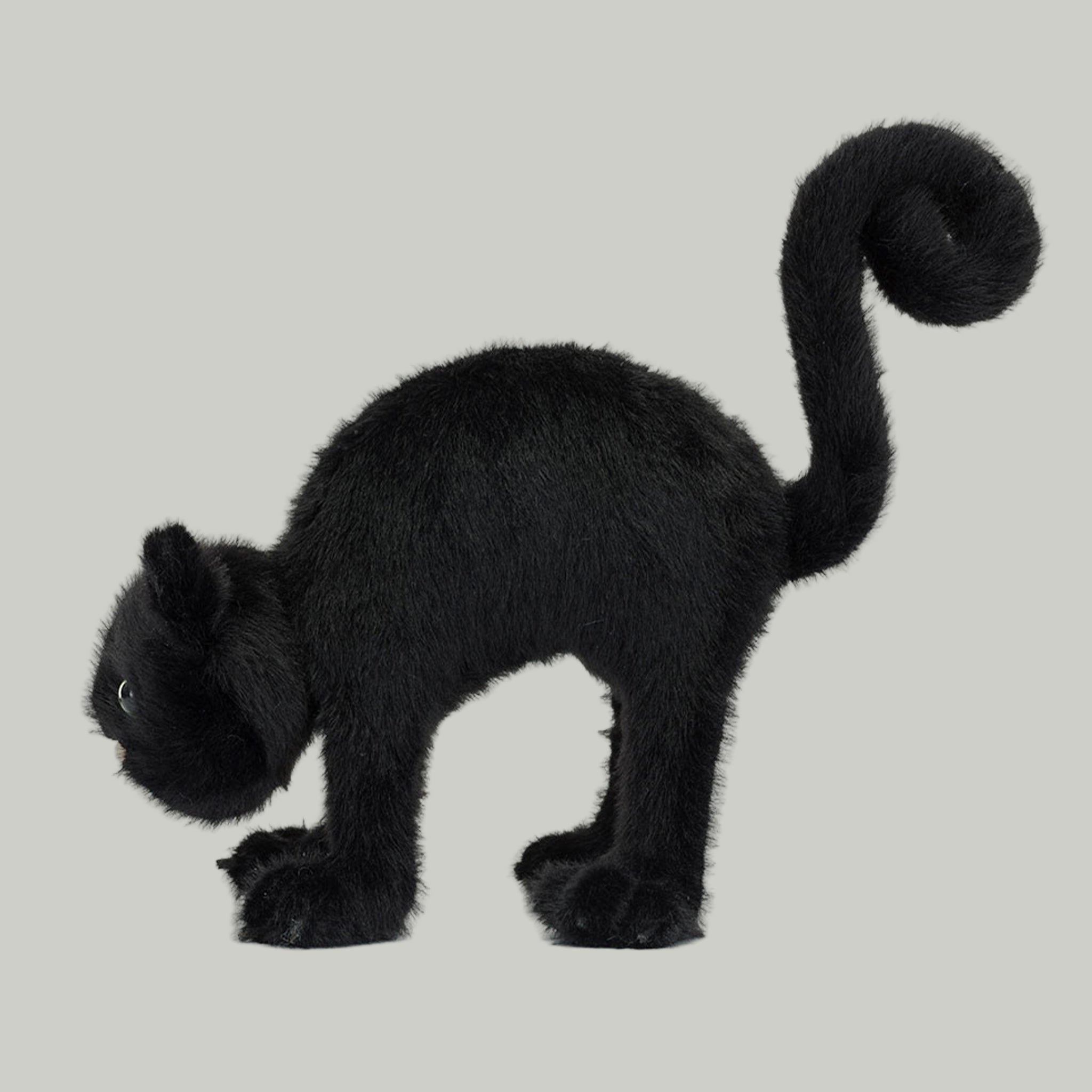 A black cat shaped stuffed animal toy with a spooky arched back. 