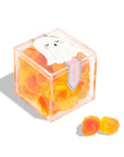 A clear acrylic box of orange and yellow ghost shaped gummy candies. 