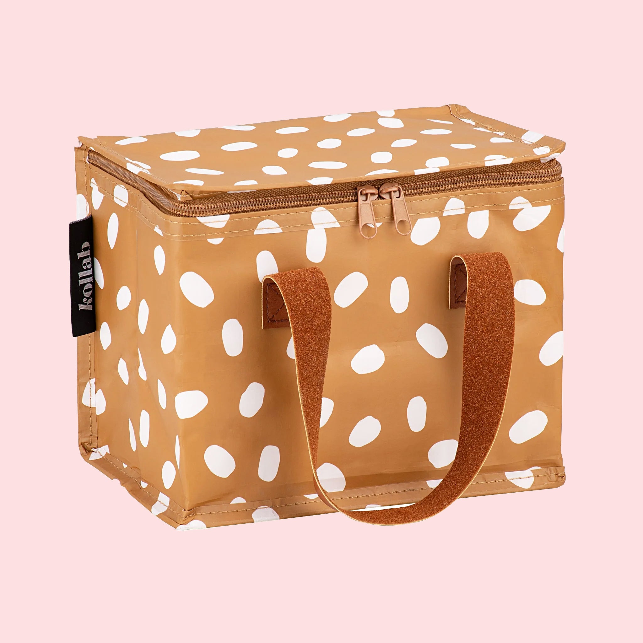 A brown and white spotted lunch box with a darker brown strap. 
