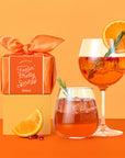 A gift box themed with accessories to go along with an aperol spritz. 