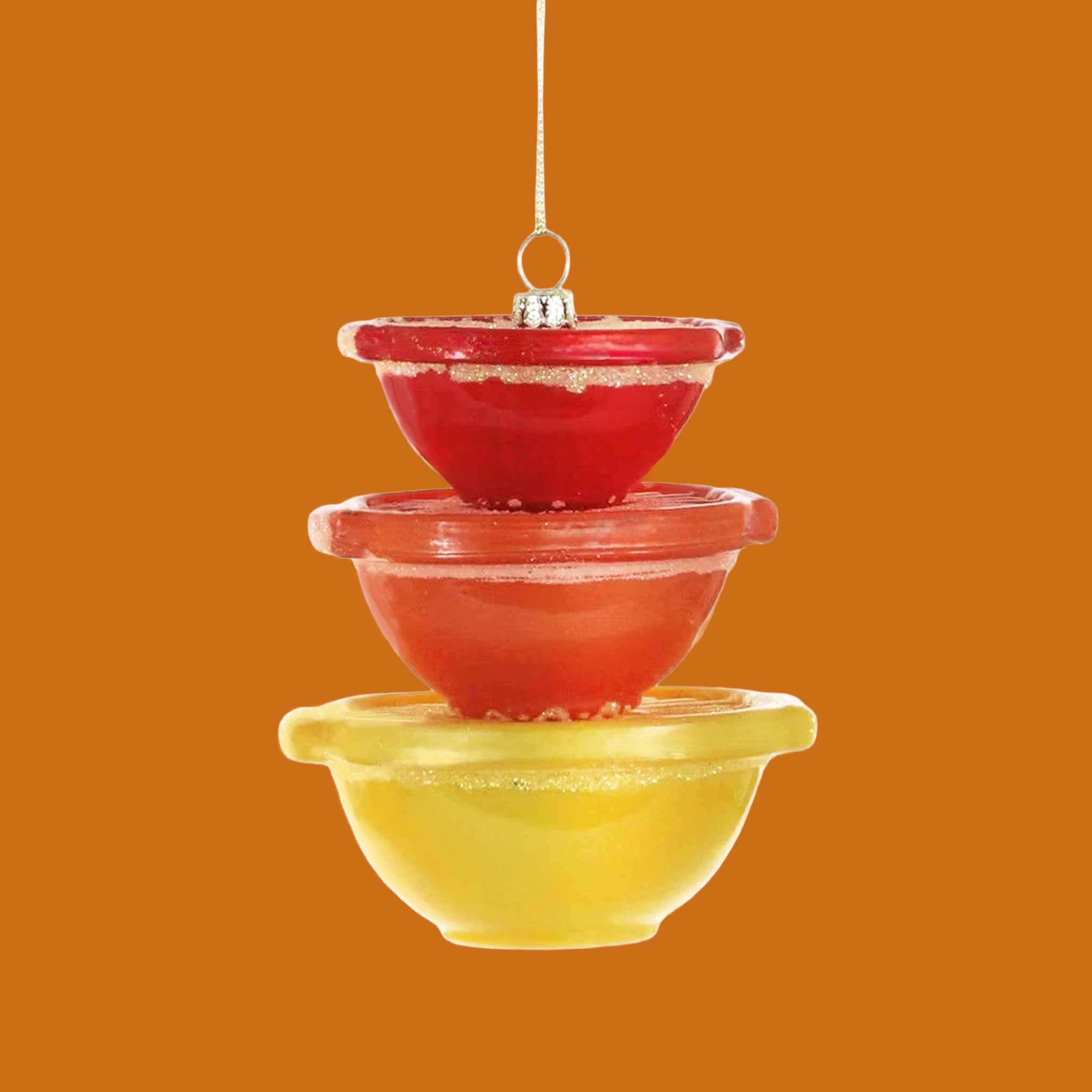 An ornament that looks like stacked bowls in yellow, orange and red. 