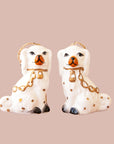 A pair of white dog shaped ornaments. 