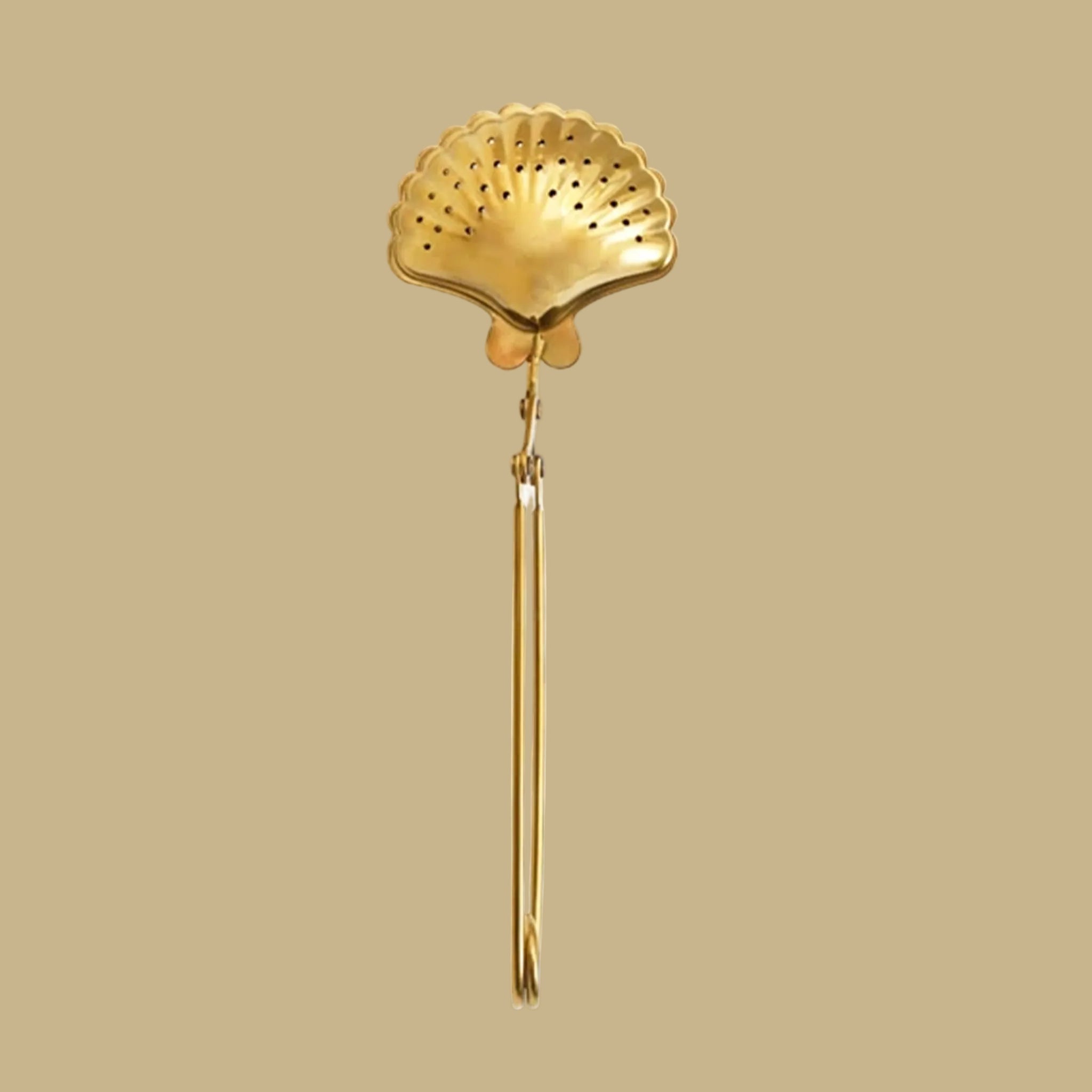 A gold shell shaped tea infuser. 