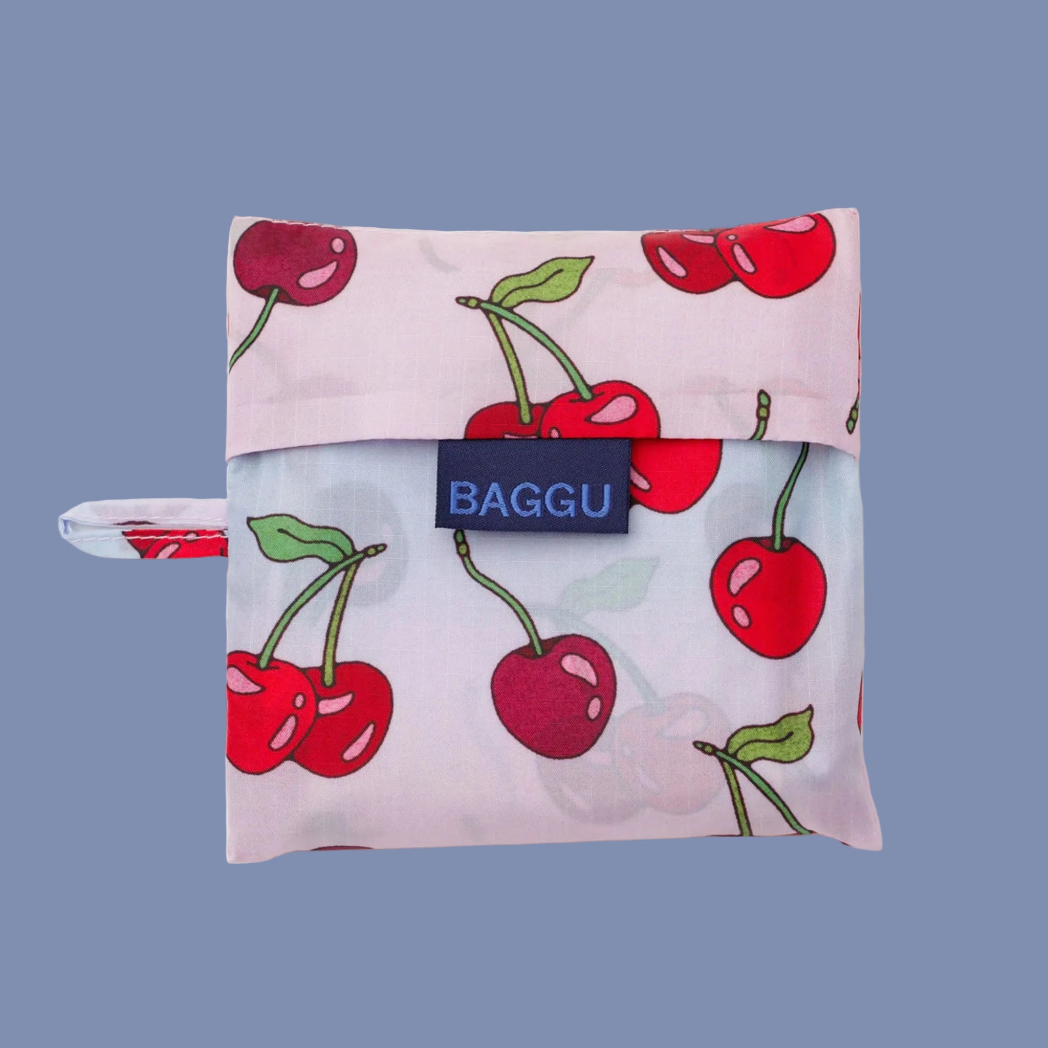 A light pink and blue ombre nylon tote bag with a cherry print. 