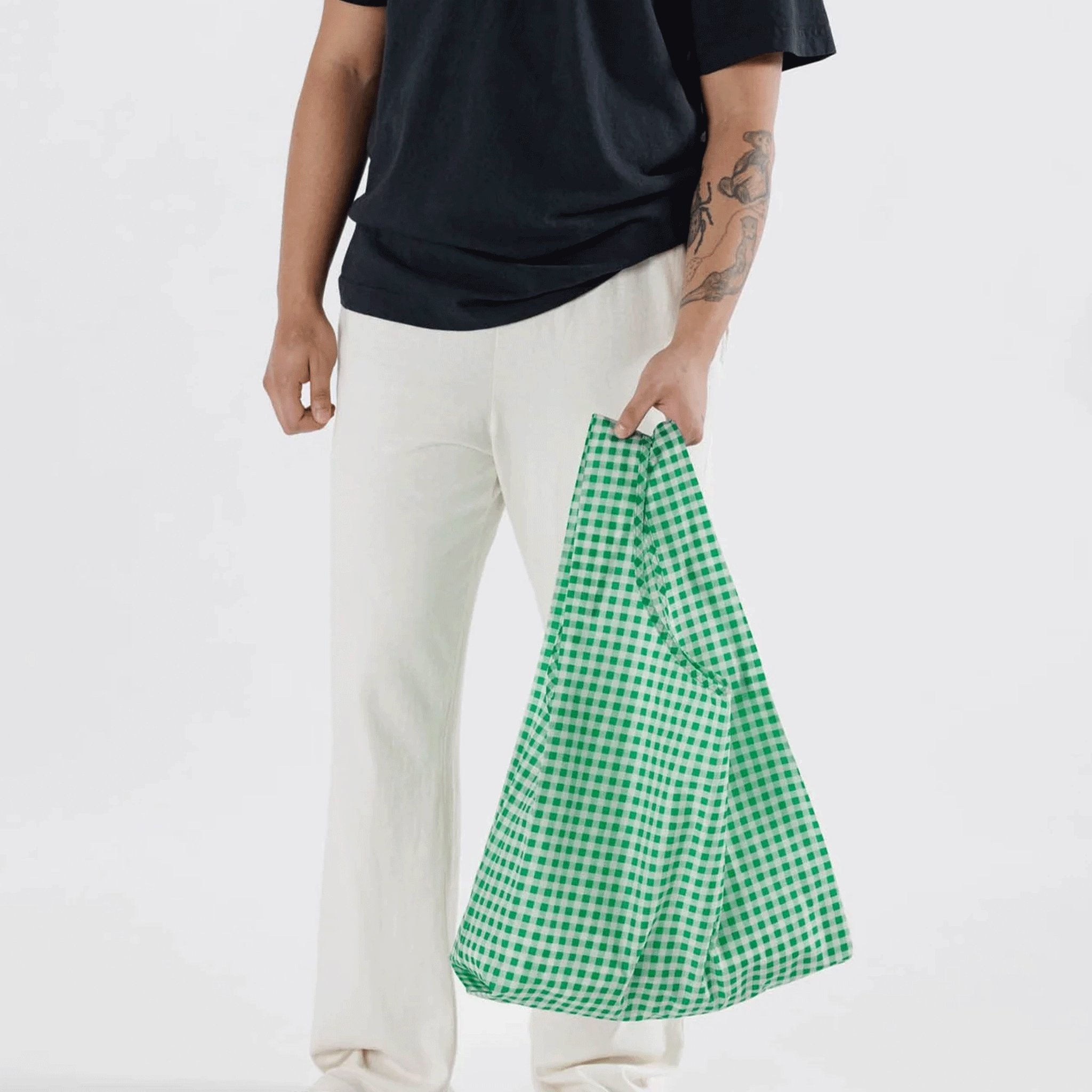 A model wearing a green and white gingham printed nylon tote bag.
