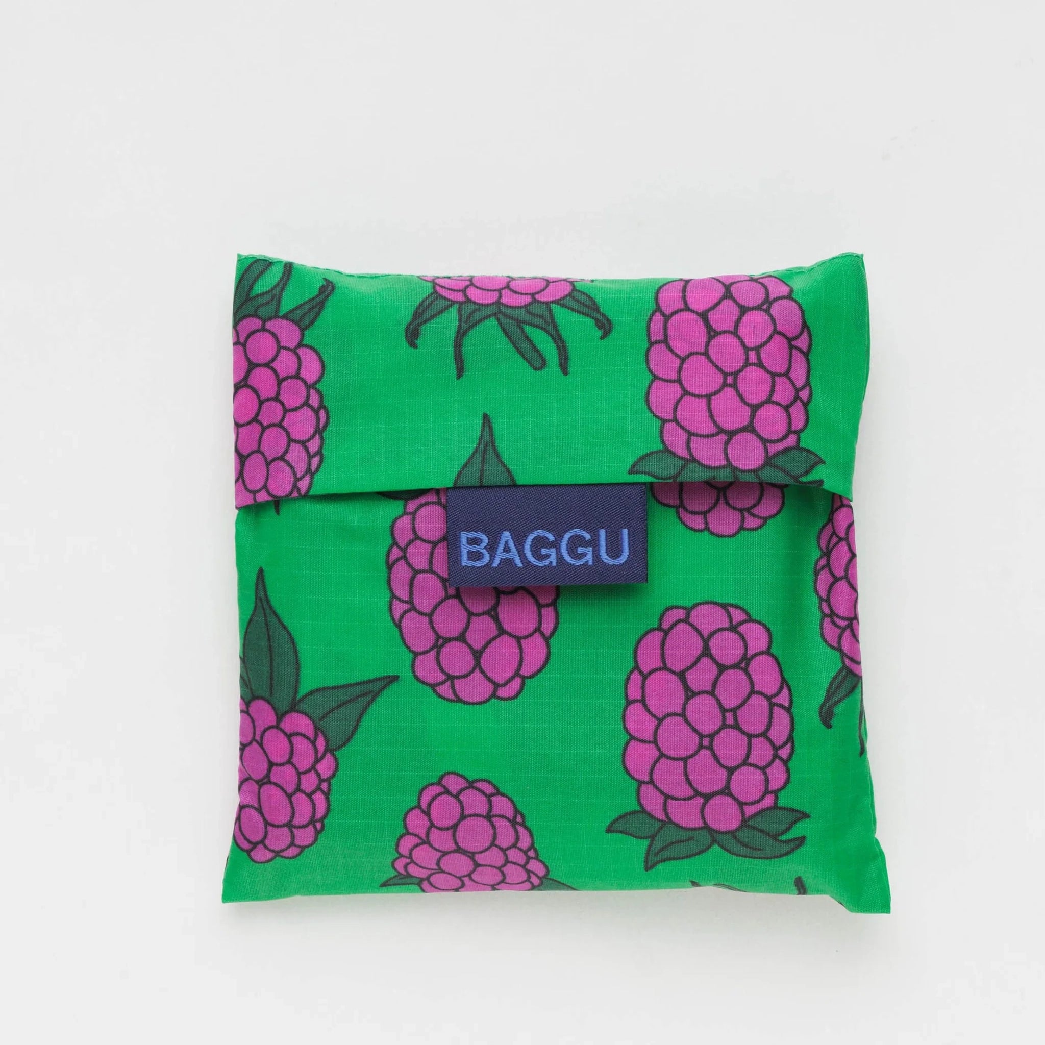 The same raspberry printed nylon bag folded up into a square pouch for easy traveling. 