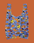 A purple reusable nylon bag with a charlie brown pumpkin patch pattern all over. 