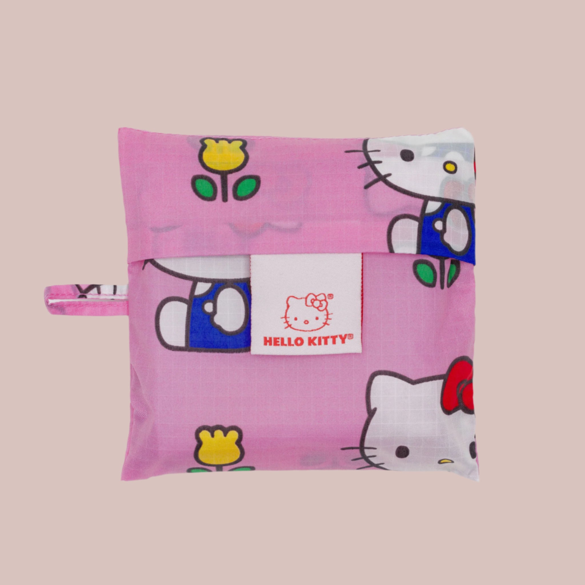 A hot pink nylon, foldable tote bag with a Hello Kitty and floral print. 