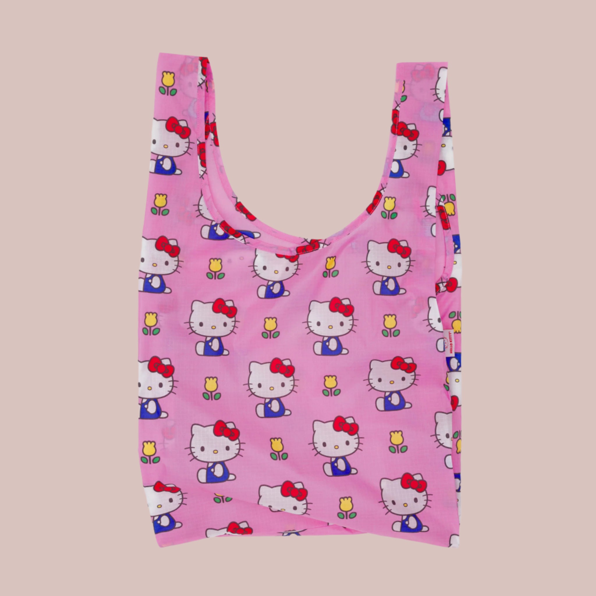 A hot pink nylon, foldable tote bag with a Hello Kitty and floral print. 