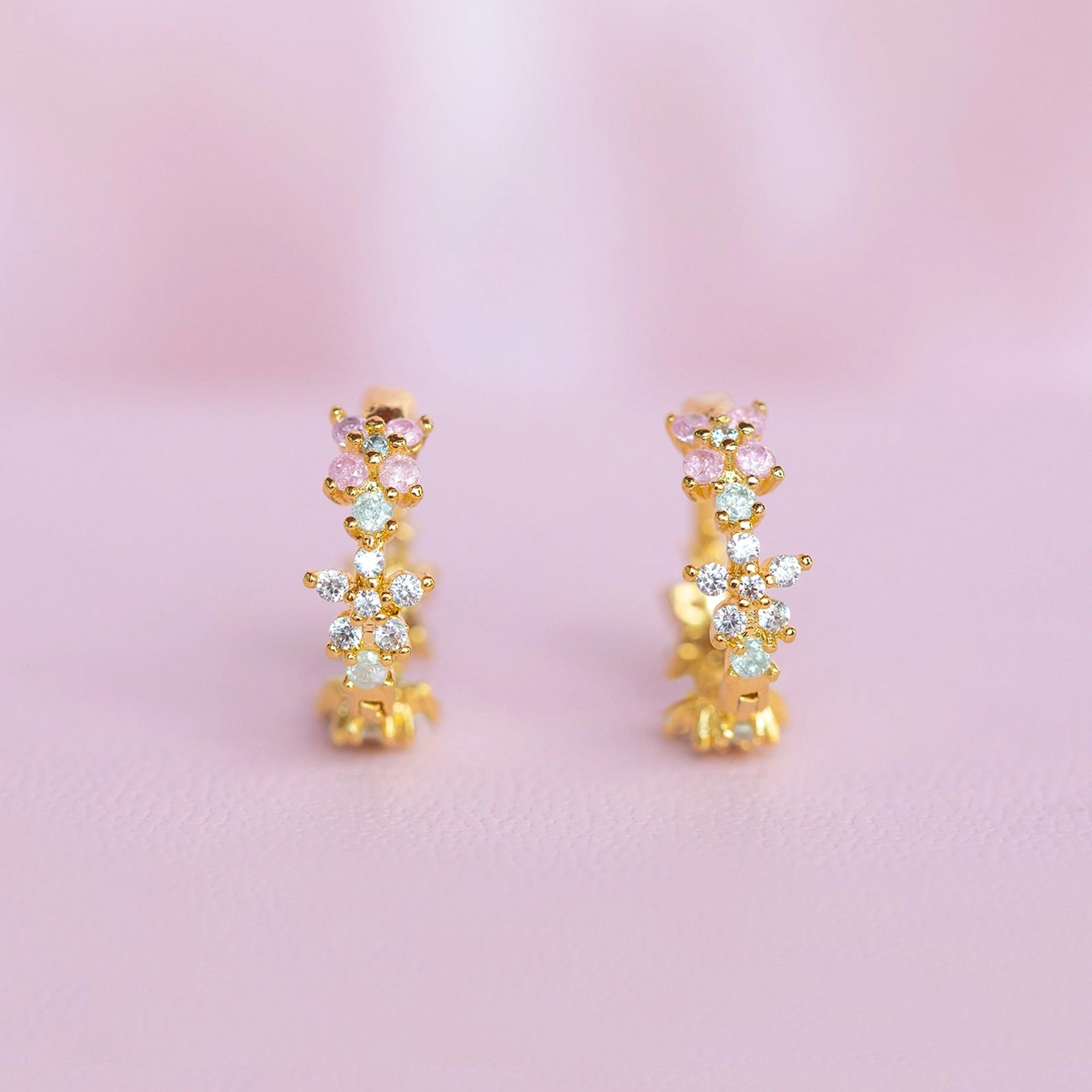 A gold pair of star and cz stone huggie hoops. 