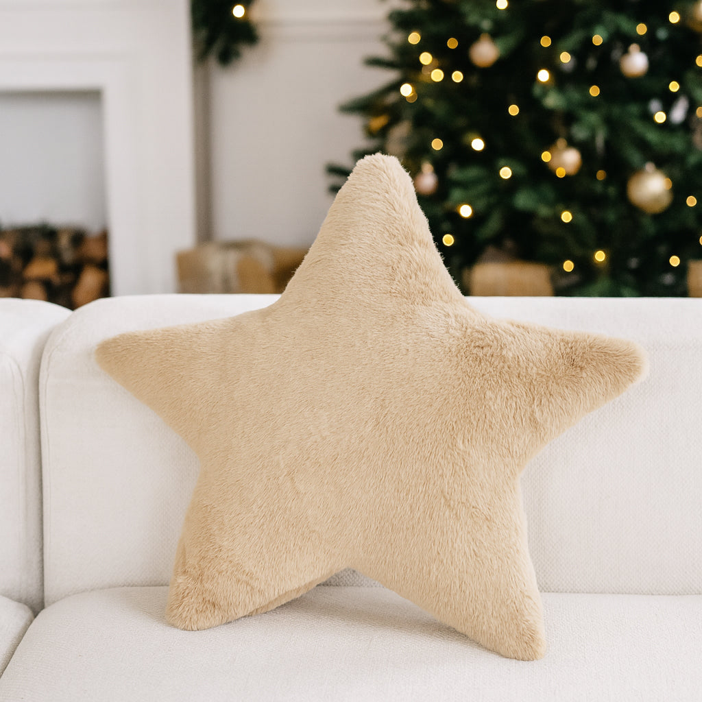 star shaped pillow on white sofa with christmas decor in background