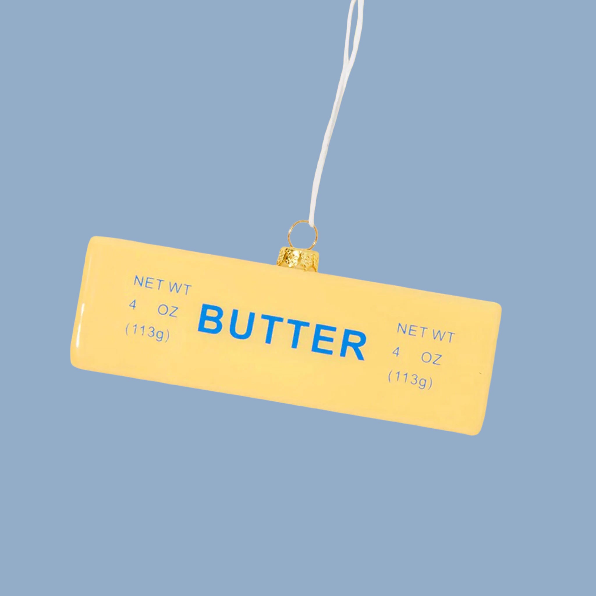 A yellow stick of butter shaped ornament with blue text that reads "butter"