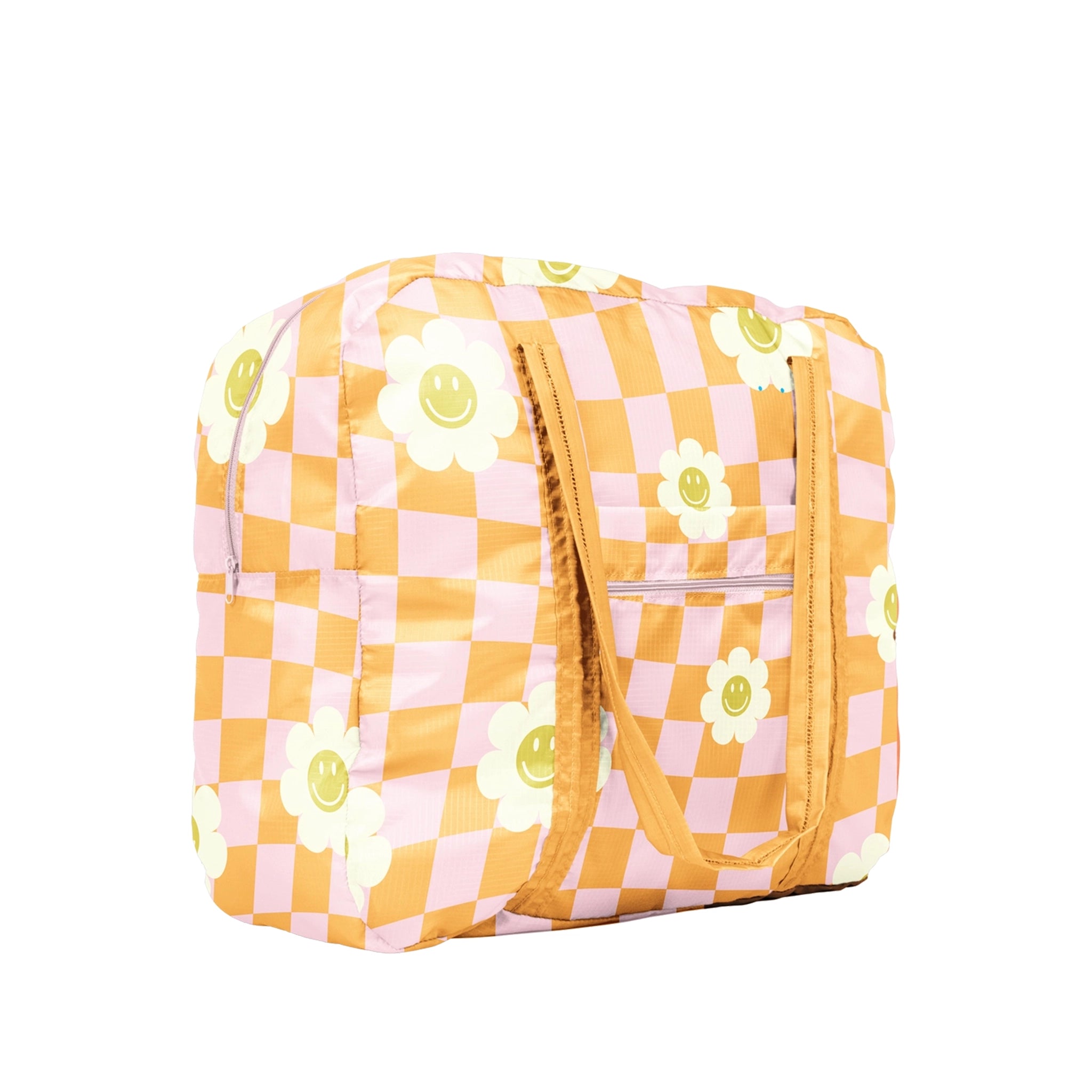 On a white background is an orange and pink checkered tote bag made of ripstop nylon. It features two shoulder handles and also has white and yellow smiley face daisies all over. 