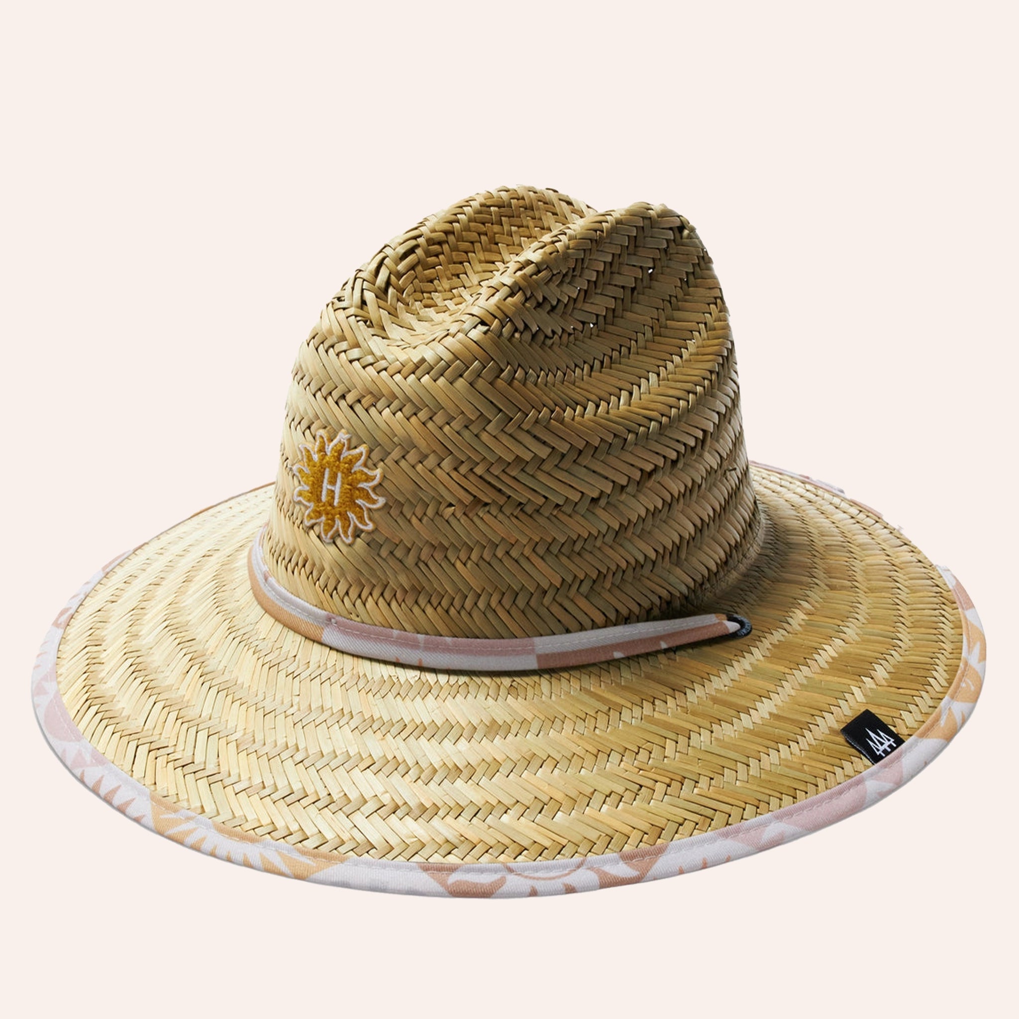 On a white background is a straw hat with a sun design on the underside of the brim. 