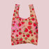 A strawberry printed nylon tote bag. 