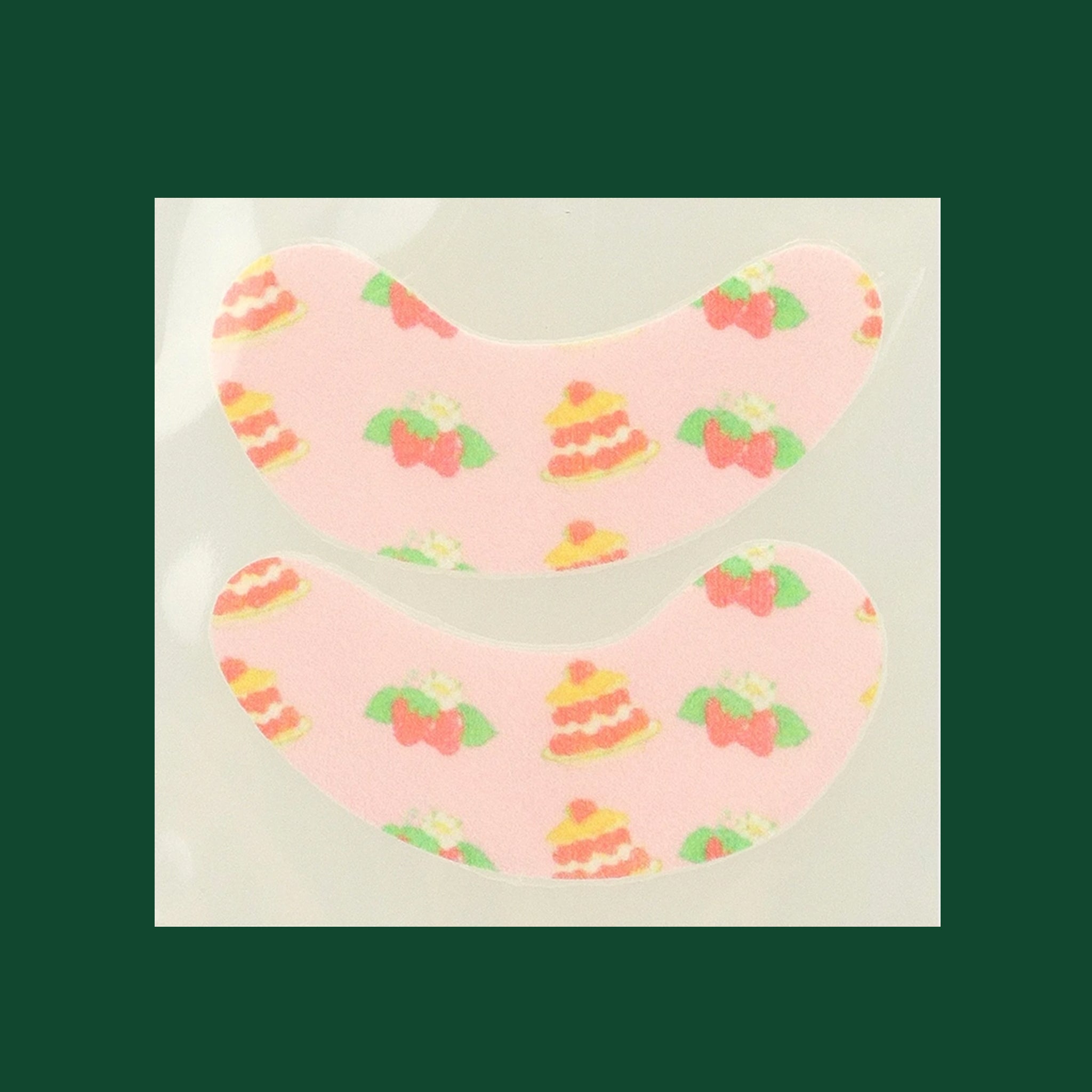 A pair of strawberry shortcake themed under eye patches. 