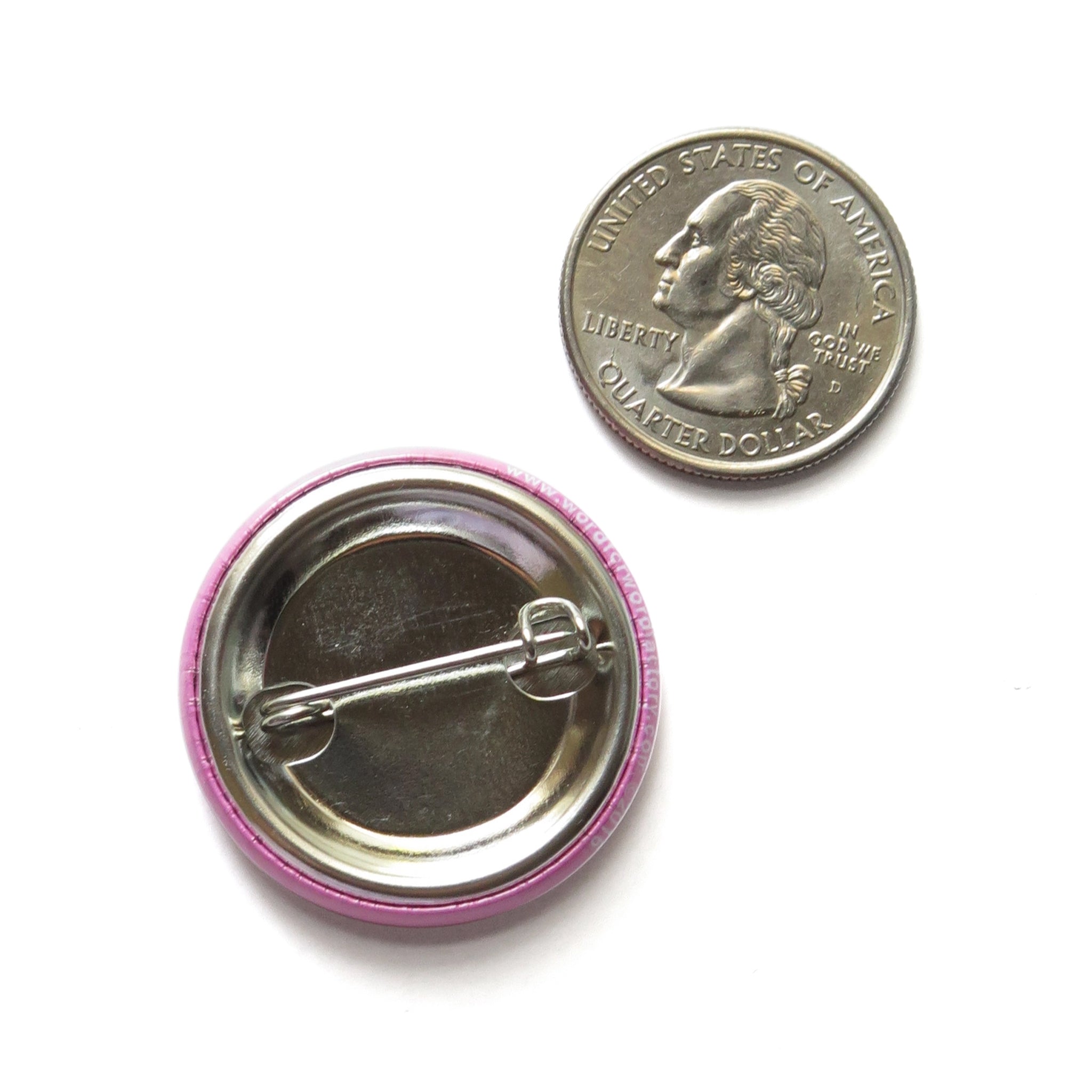 Button badge with pink rim and metal clasp next to a quarter for size comparison on a white background