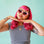 A pink pair of heart shaped sunglasses. 