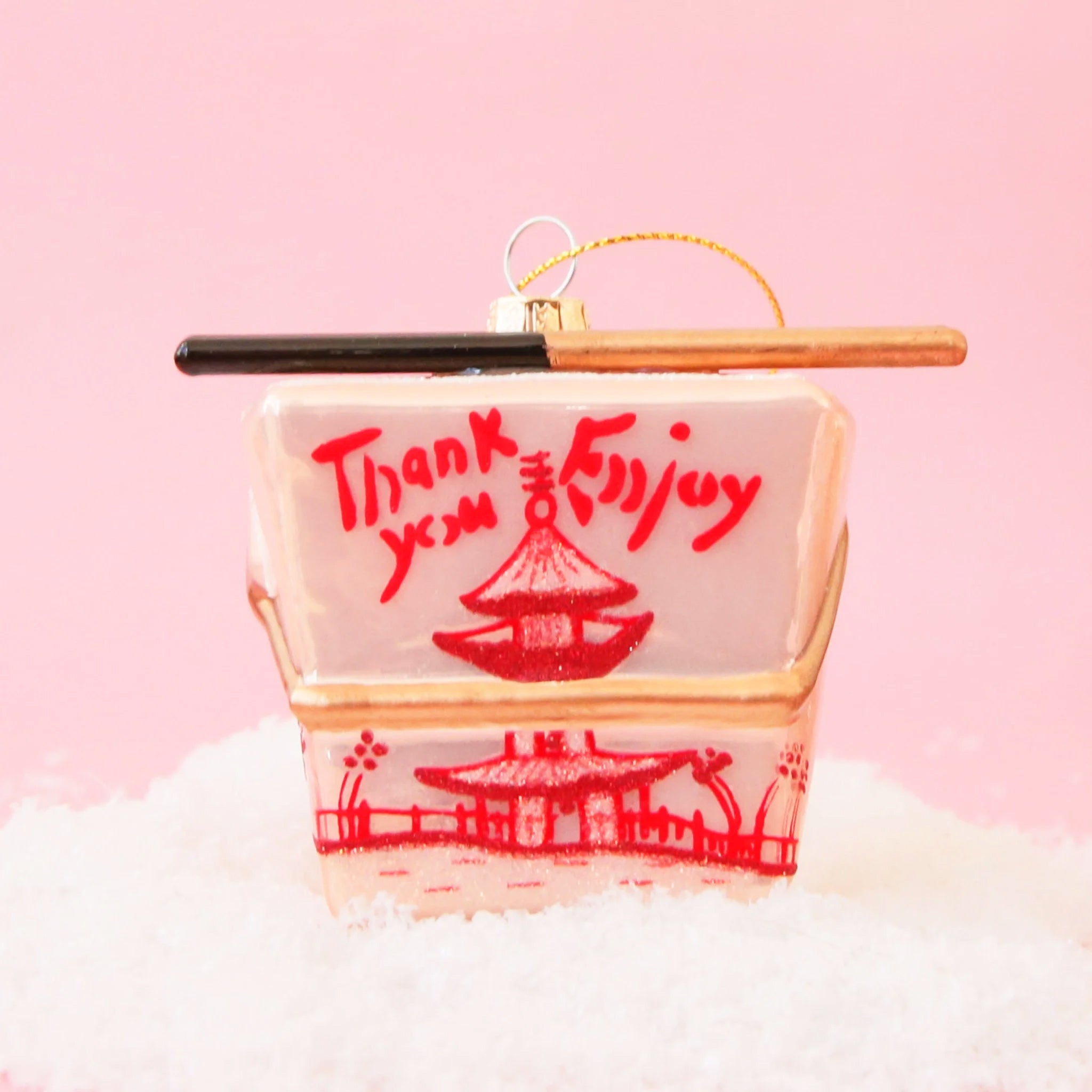 A glass ornament made to look like a pink Chinese takeout box with a pair of chopsticks across the top.