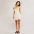 A white mini flowy dress with thin shoulder straps. 