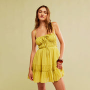 A lime green mid thigh dress with a strappy back and shoulder straps. 