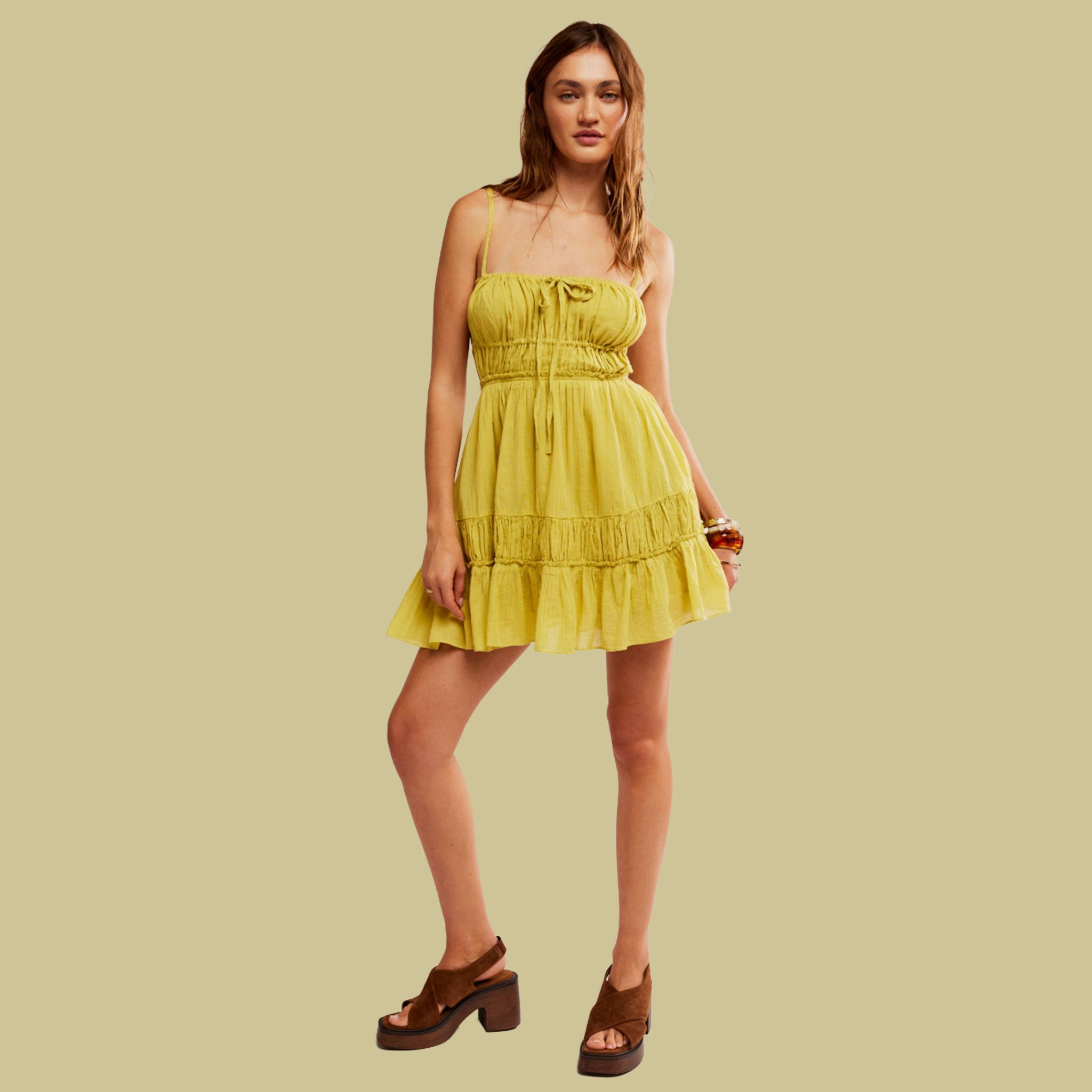 A lime green mid thigh dress with a strappy back and shoulder straps. 