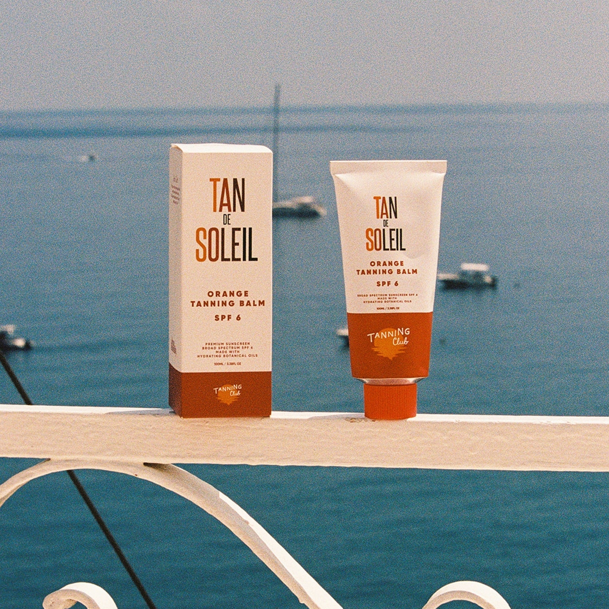 Tan de Soleil tanning balm and cream with a scenic ocean view in the background