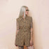 Person wearing a leopard print romper against a beige background