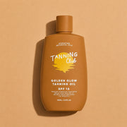 Tanning oil bottle with 'Tanning Club' branding on a beige background