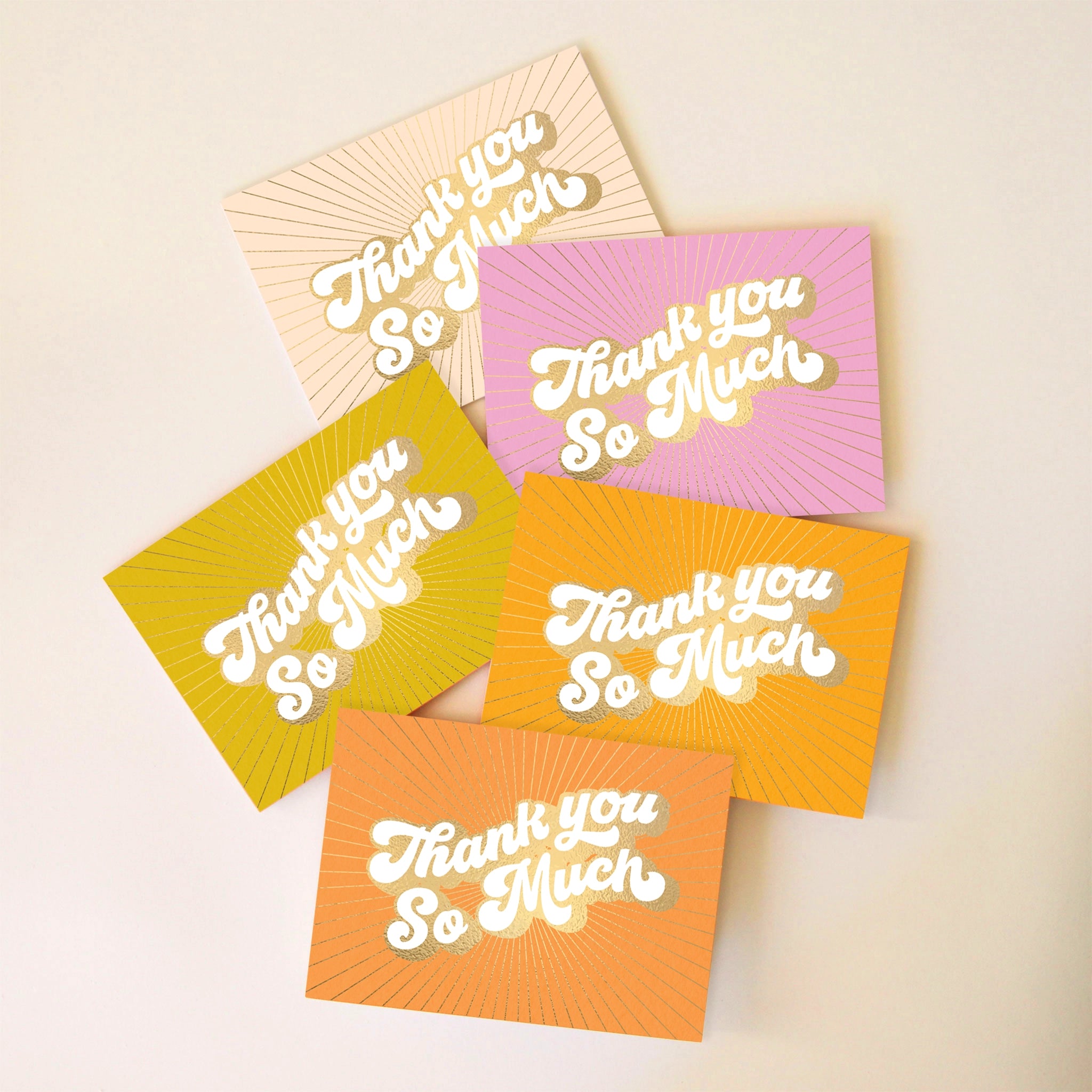 On an ivory background is a pack of 5 thank you cards in a variety of colors that all read, &quot;Thank You So Much&quot; in white letters and gold foiled outlined.