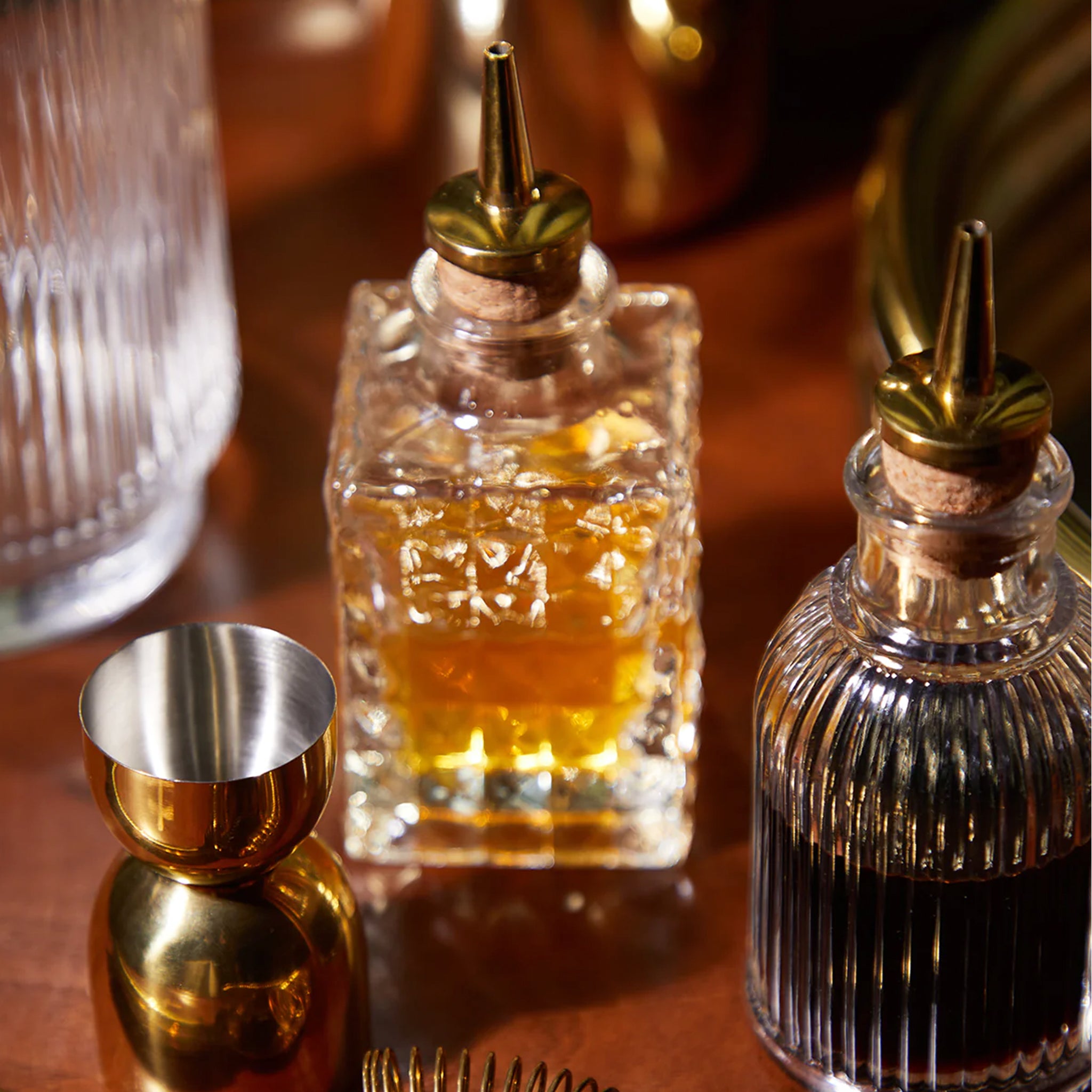 Two glass bitters bottles with gold spouts.