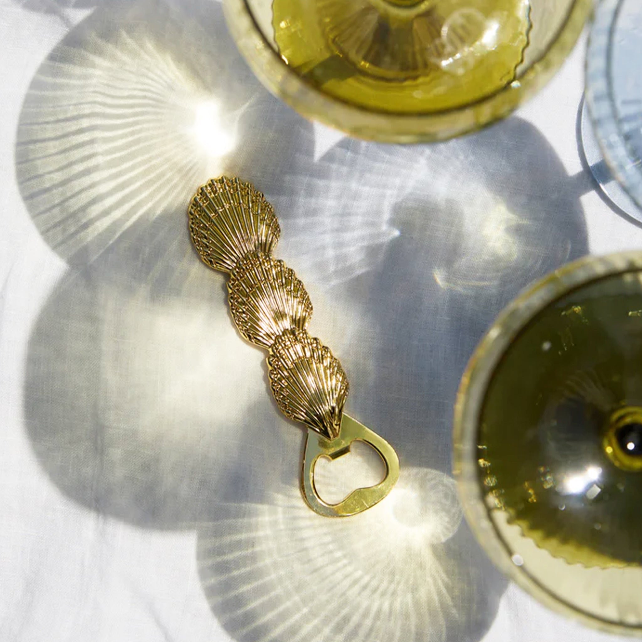 A gold shell shaped bottle opener.