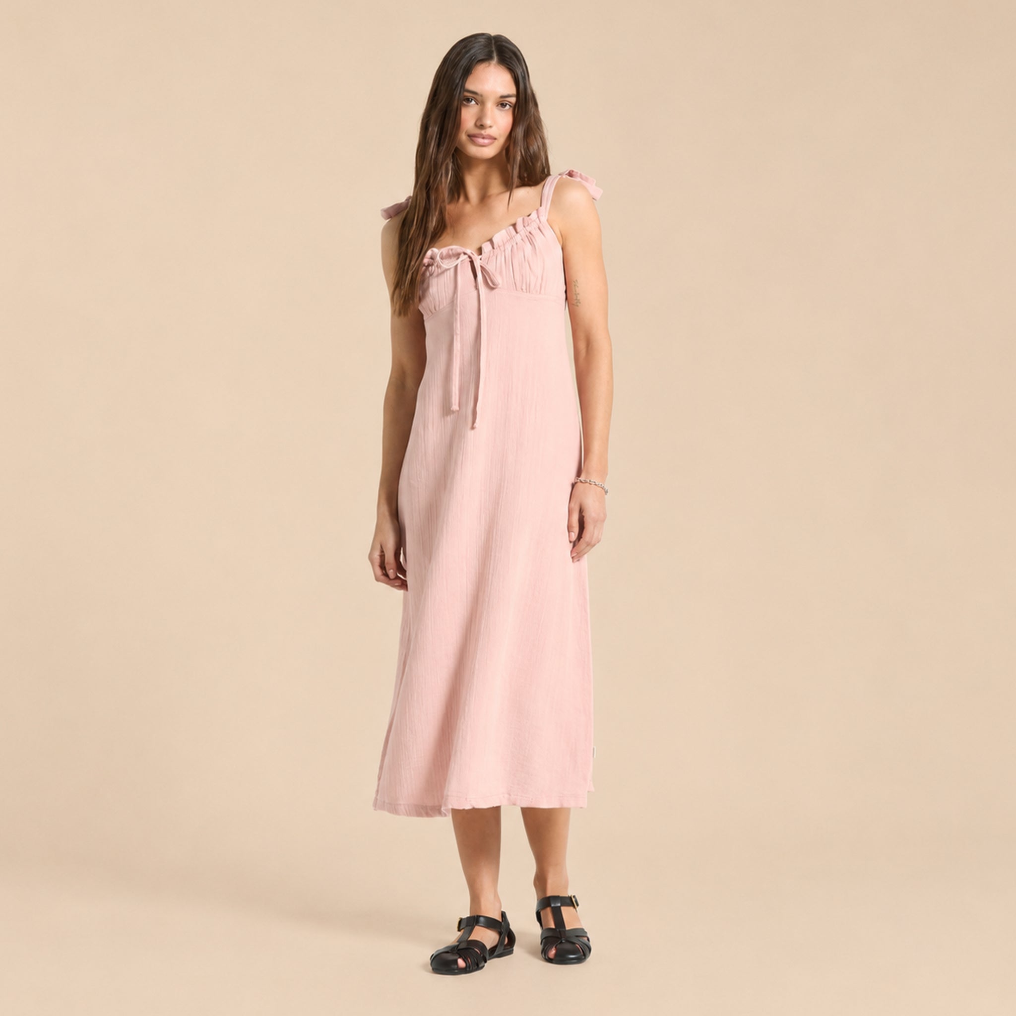 Woman wearing a pink dress against a beige background