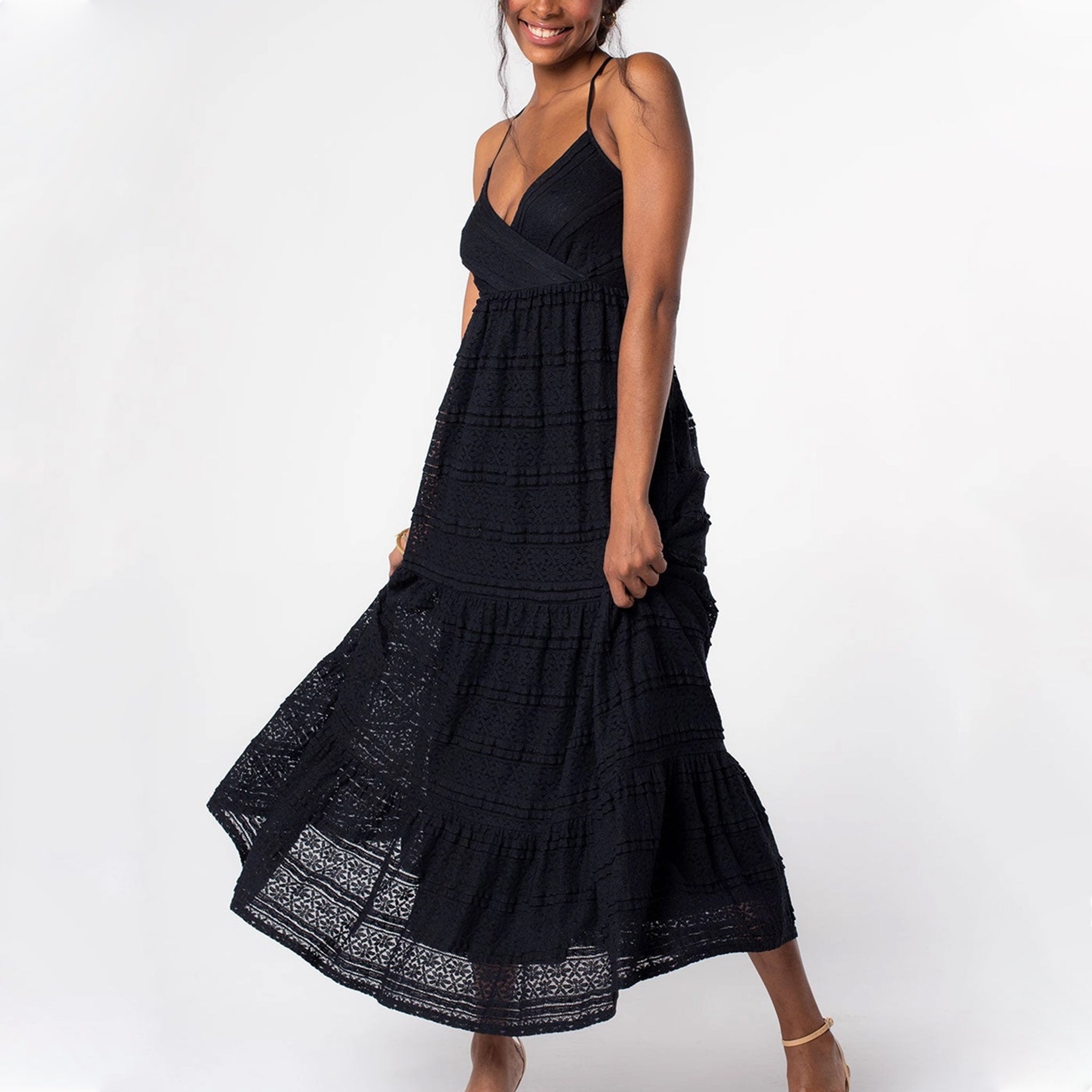 A black lace flowy dress with a v-neck and spaghetti straps that cross in the back. 