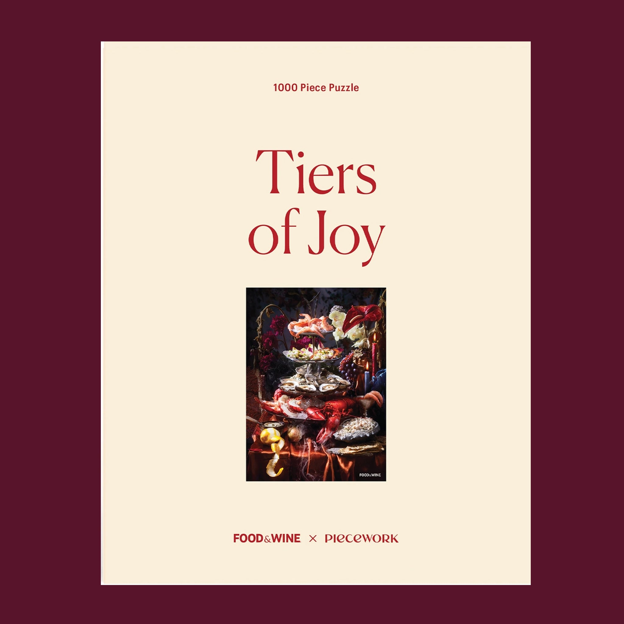 A 1000 piece puzzle box with a photo of the completed puzzle that  depicts a silver tiered tray filled with shrimps, oysters, lobster and lemons surrounded by dramatic florals and candle sticks. "1000 Piece Puzzle Tiers of Joy Piecework Puzzles".